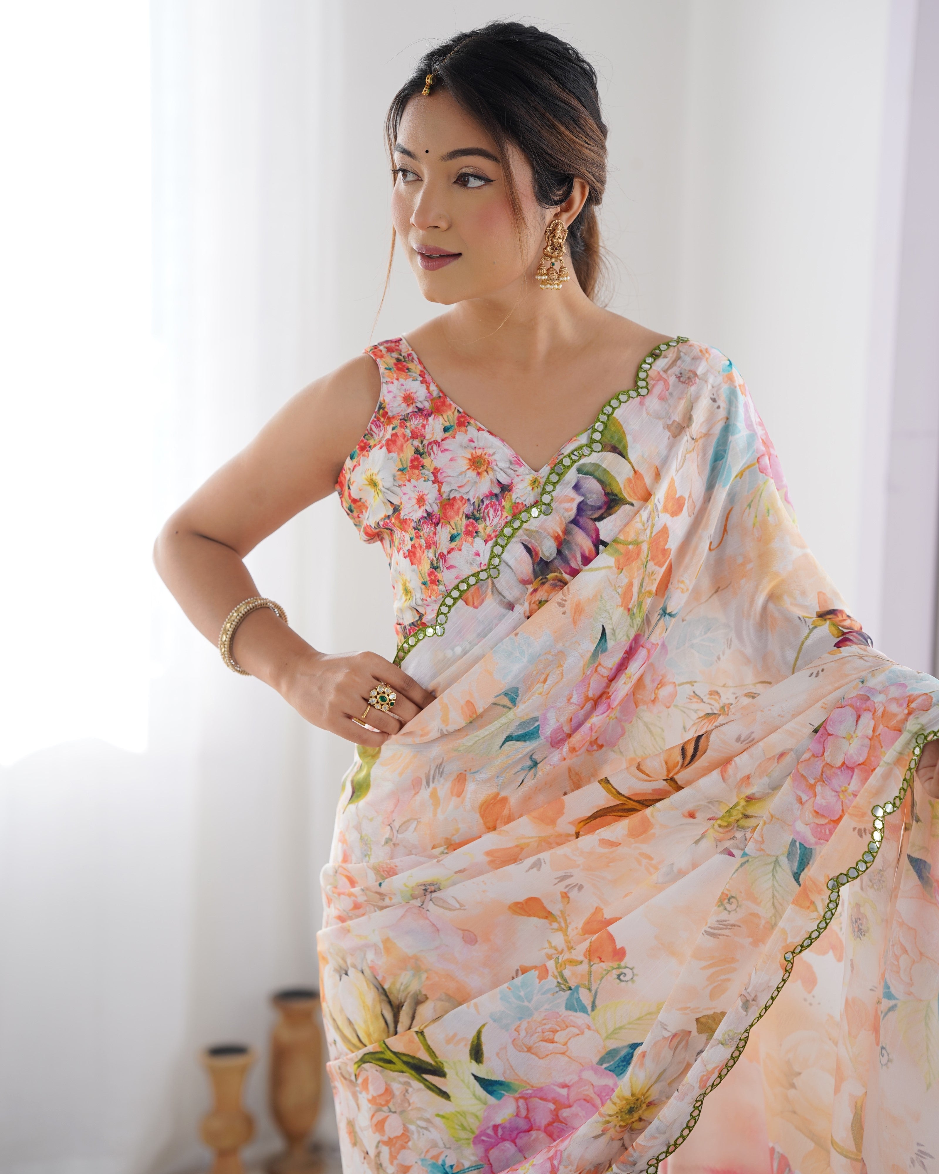 Model in elegant floral chinnon saree, showing the matching unstitched blouse design with a V-neck.