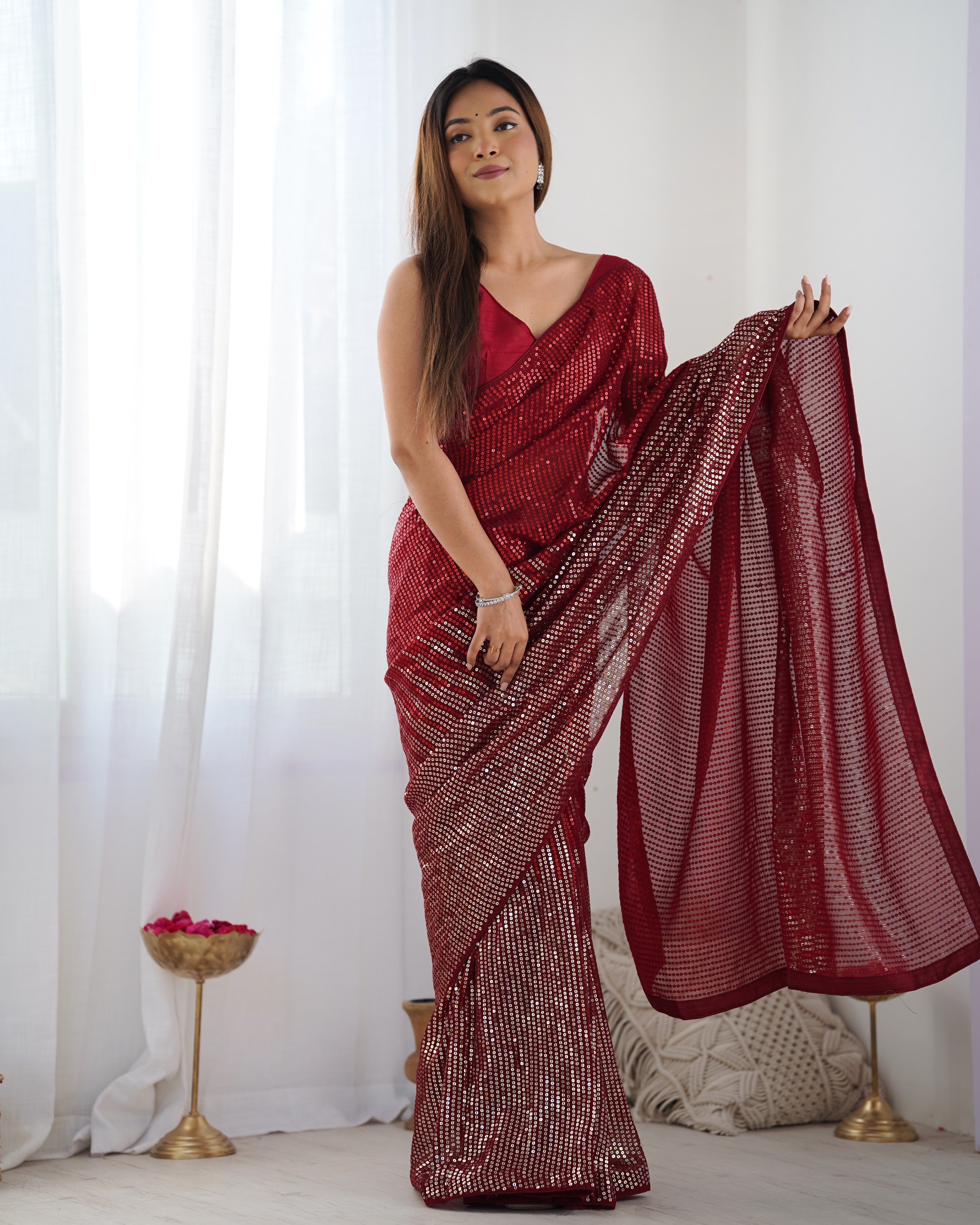 Ruby red heavy georgette saree with shimmering multicolored sequin embroidery.