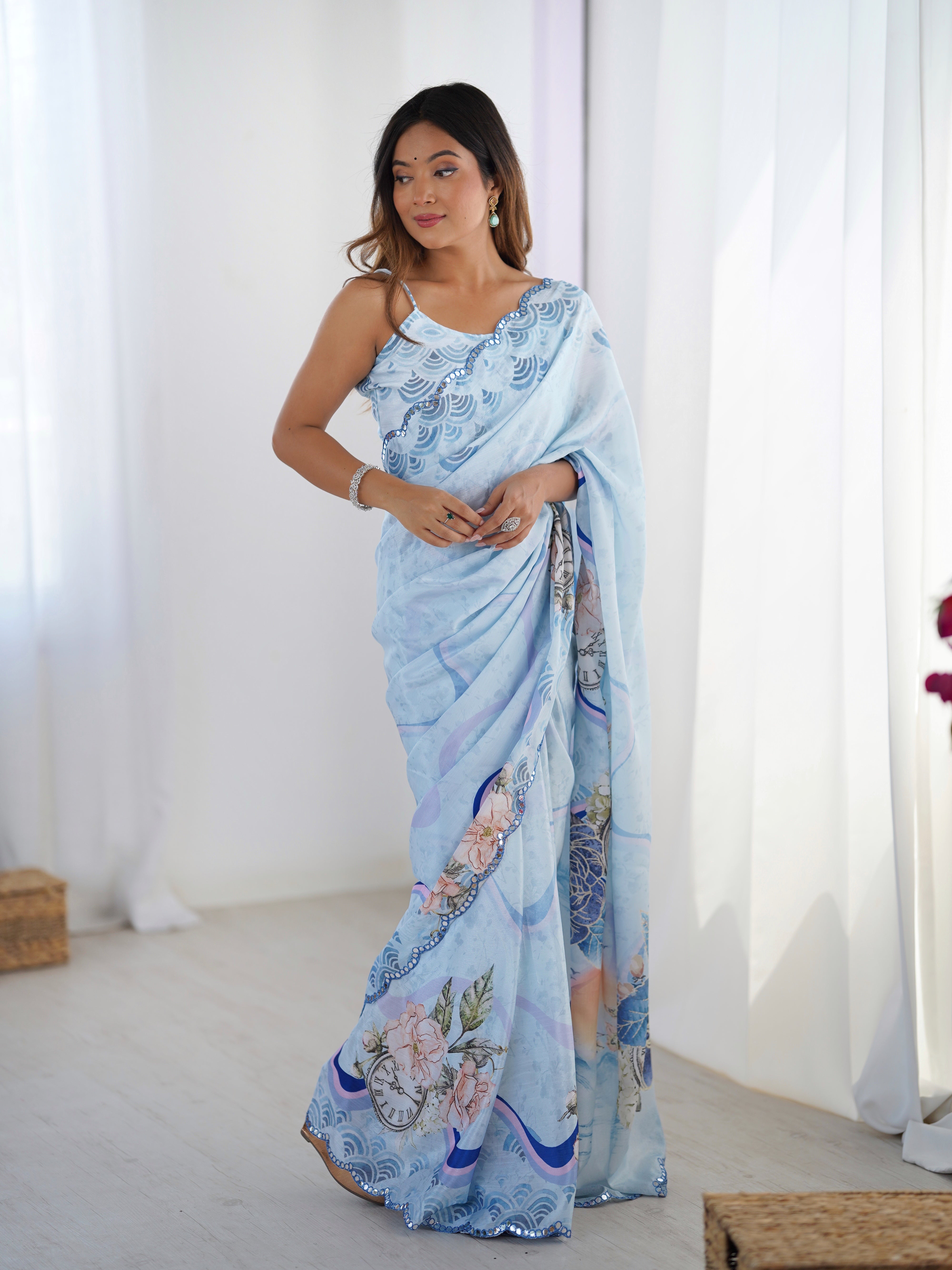 Fashion model presenting the full view of the heavy Chinnon saree, emphasizing its elegant print and sparkling border against a white background.
