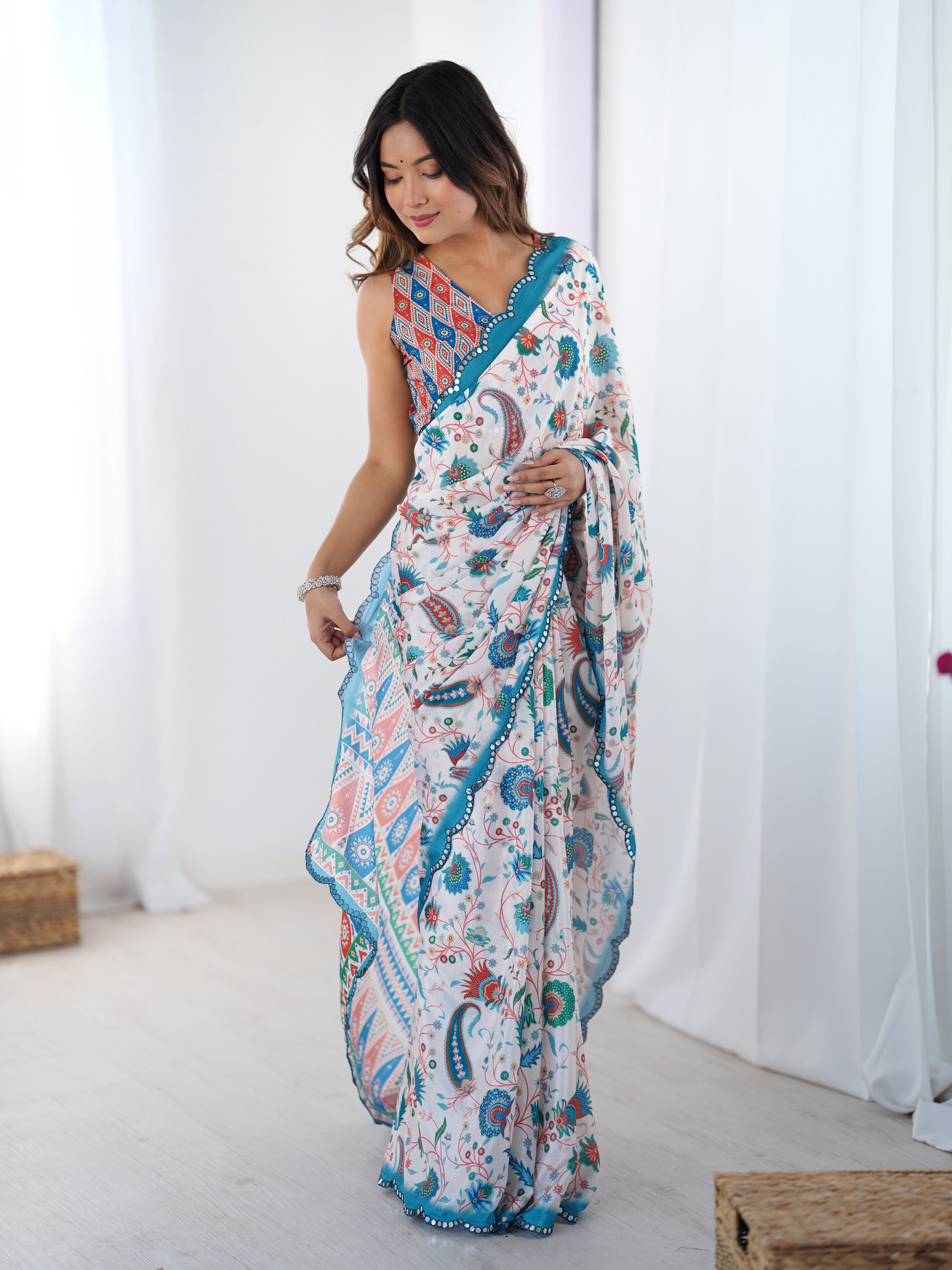 Model gracefully adjusts the pallu of the TRENDBUY DVS-28 printed Chinnon saree, highlighting its flowing fabric and vibrant patterns.
