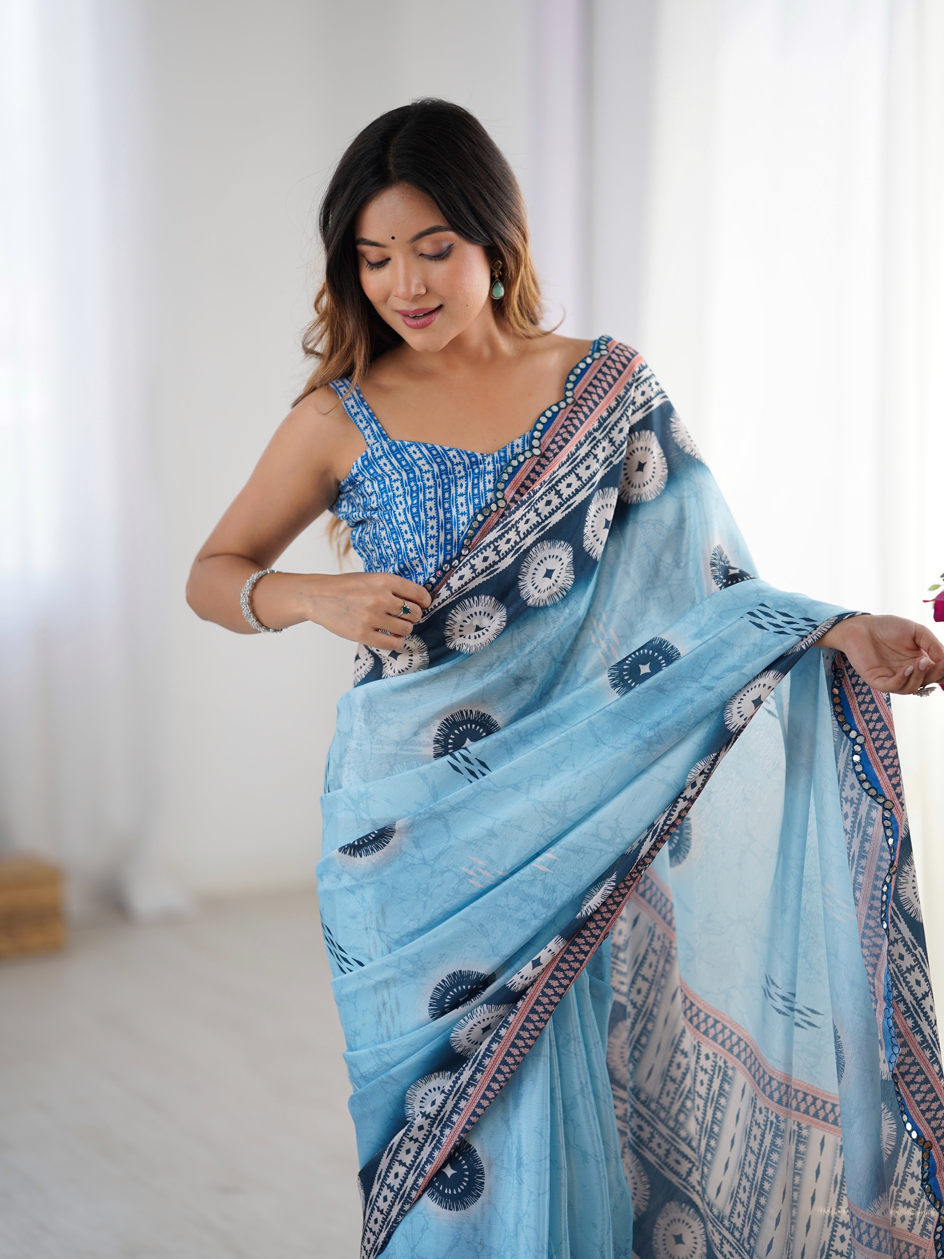 Elegant heavy Chinnon saree with intricate Kutchi mirror work lace detail and unstitched blouse.