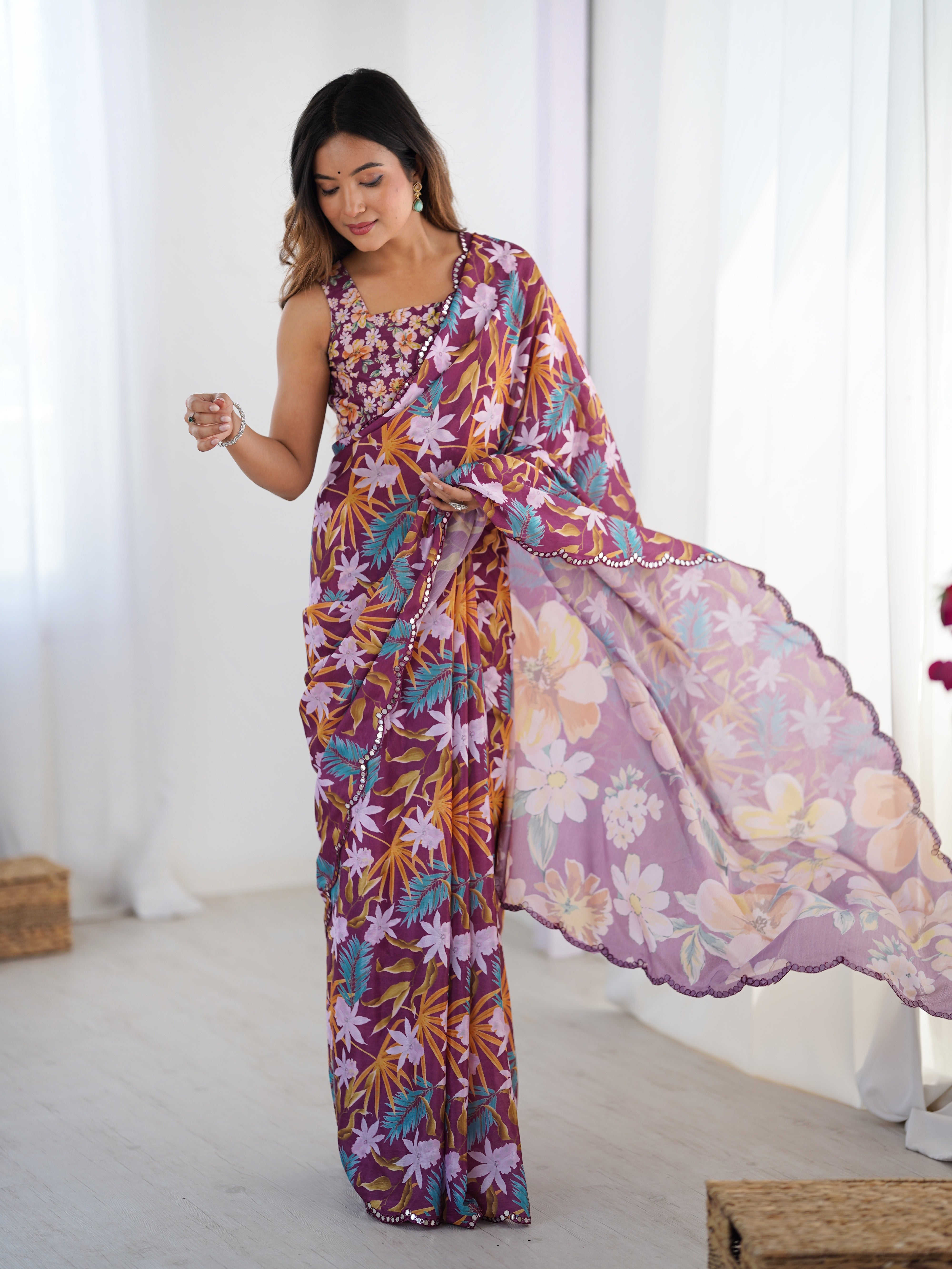 Woman playfully twirling the pallu of her TRENDBUY floral print Chinnon saree with Kutchi mirror work border.