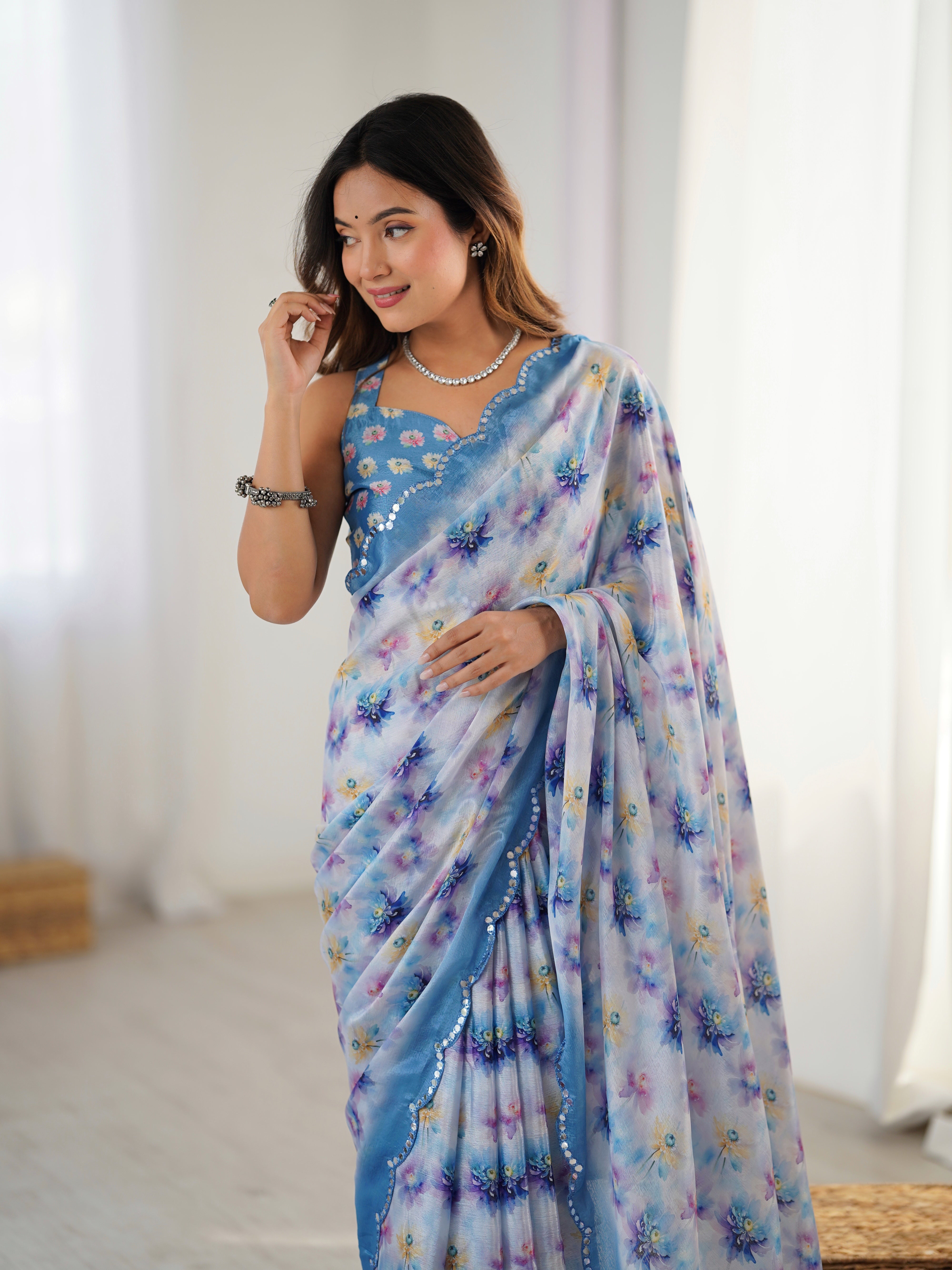 Elegant heavy Chinnon saree featuring vibrant floral print and Kutchi mirror work border.