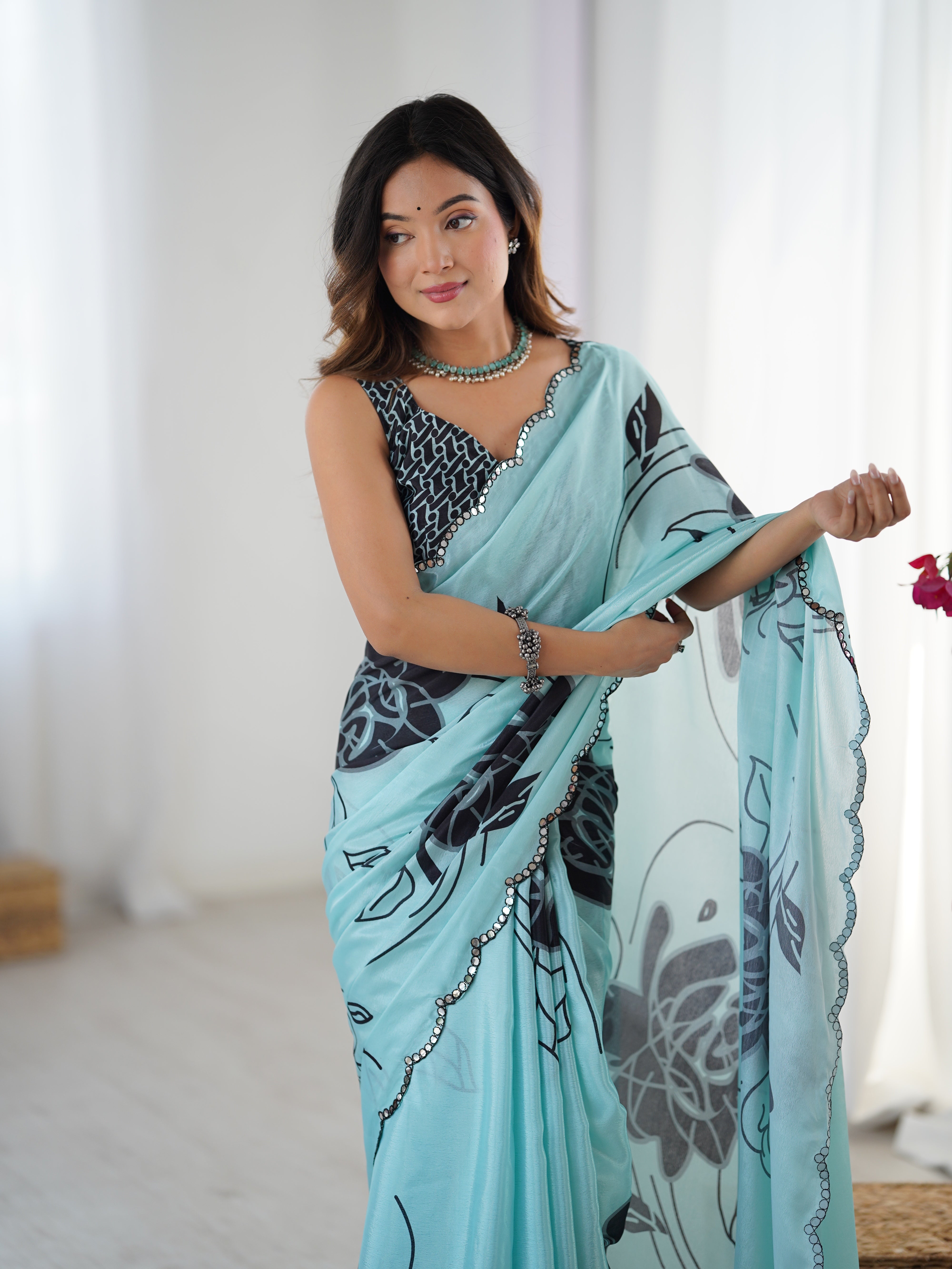 Elegant sky blue heavy chinnon saree featuring floral print and Kutchi mirror lace border