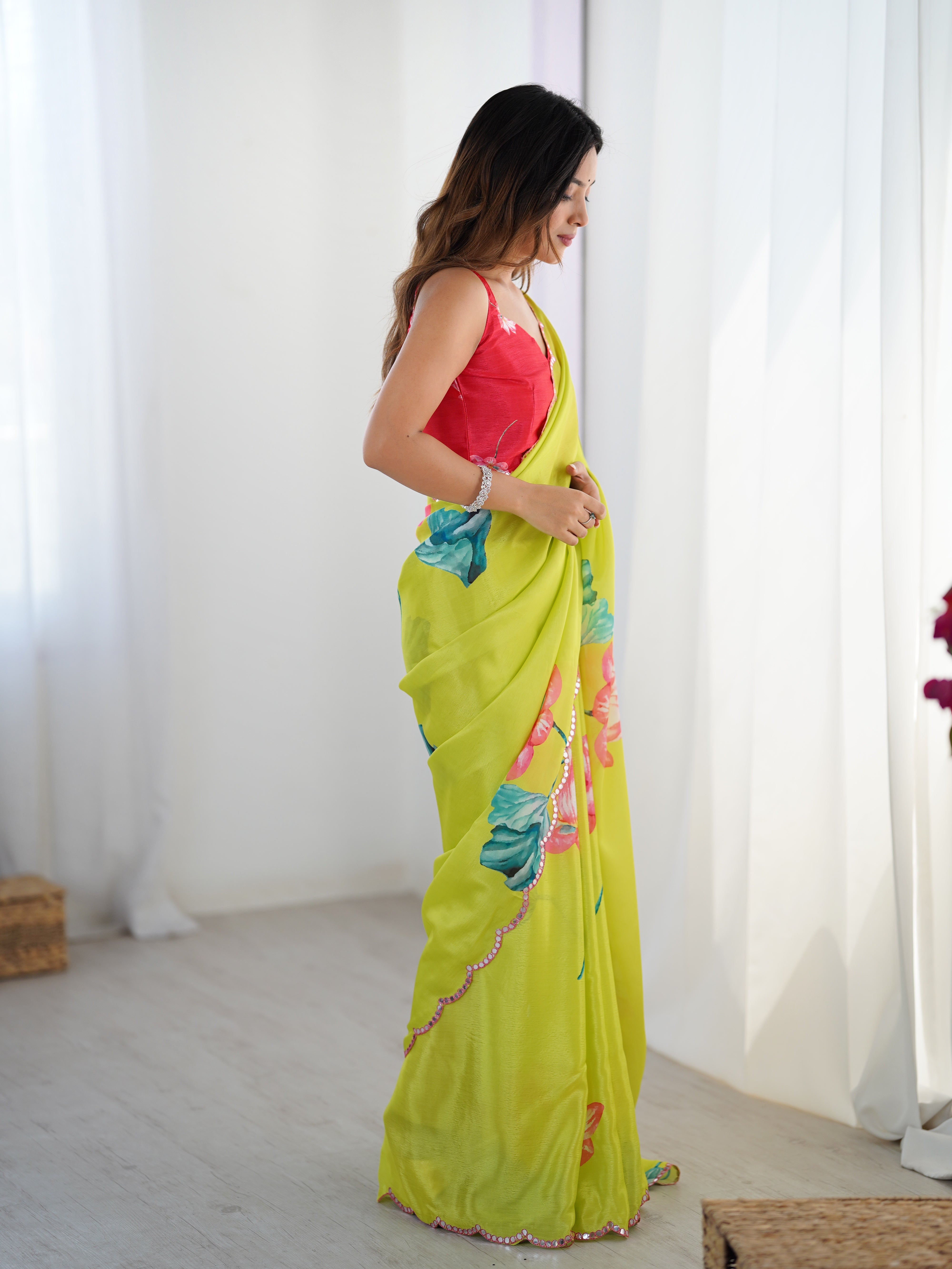 Model in a graceful side pose, accentuating the elegance of the heavy Chinnon saree and its border.