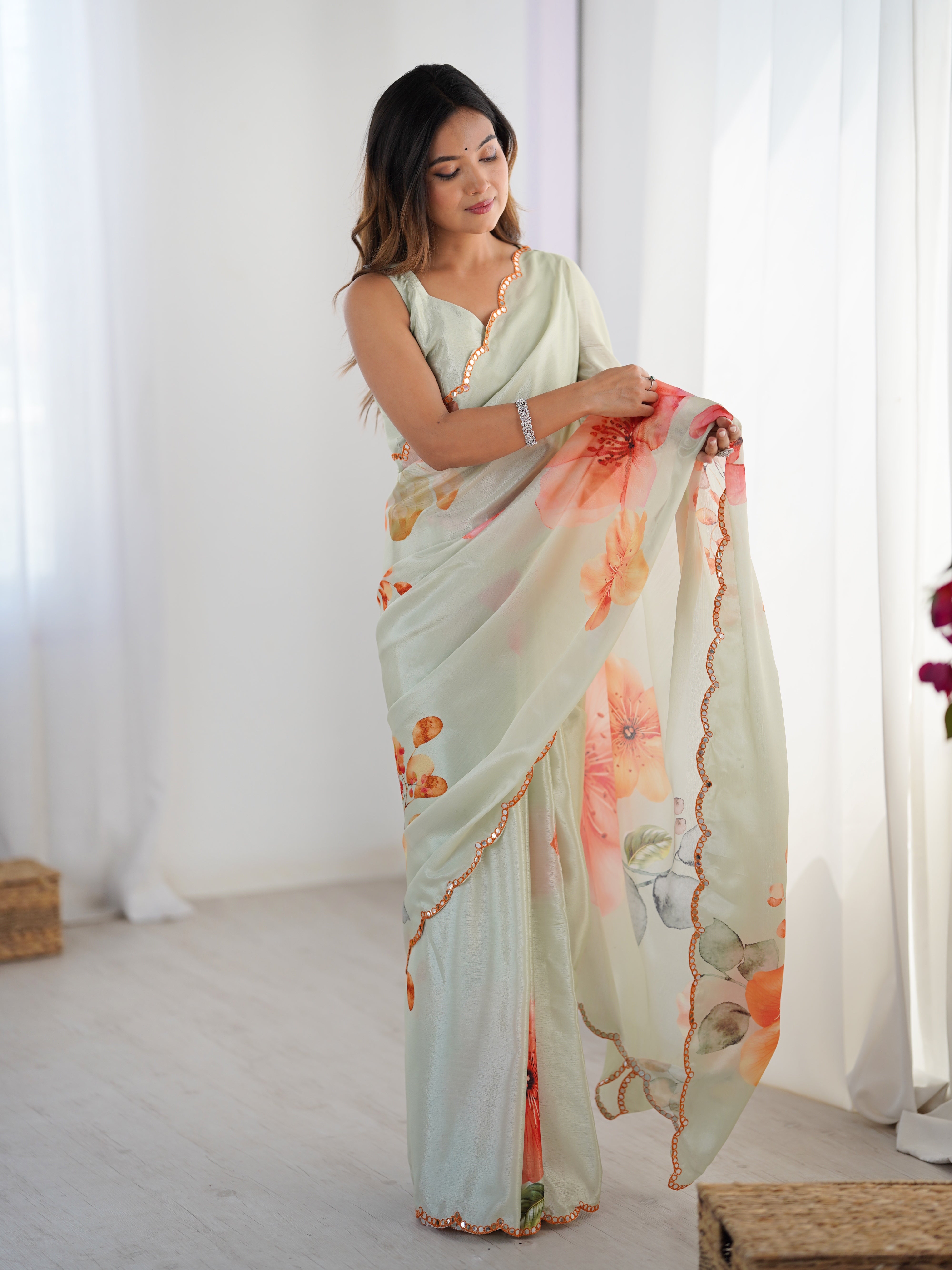 Elegant heavy chinnon saree with vibrant floral print and Kutchi mirror lace border.