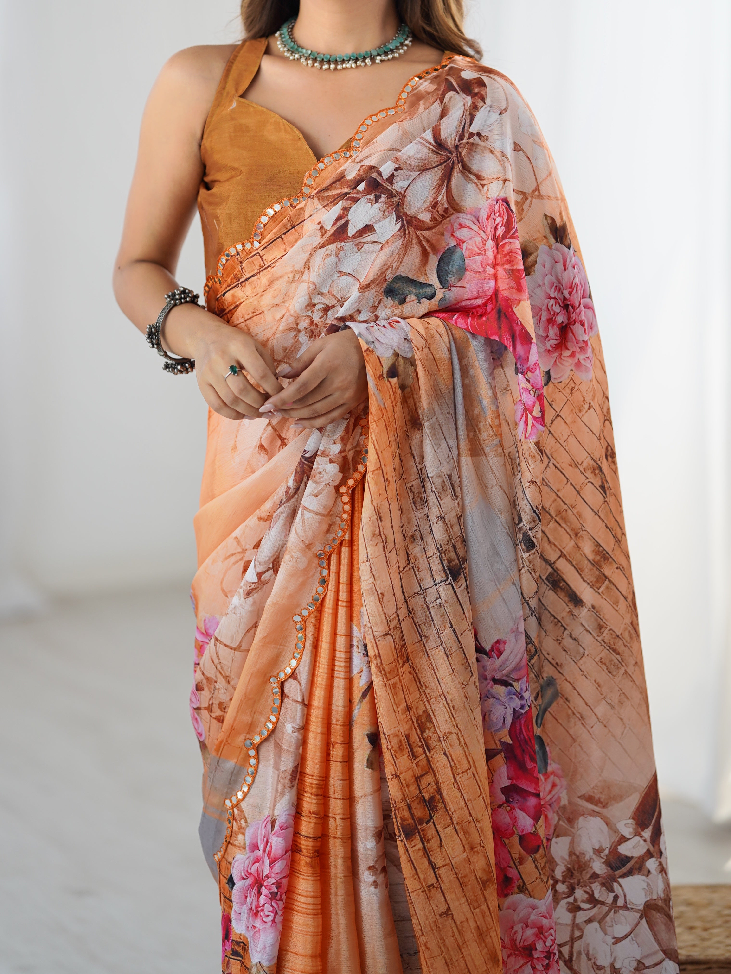 Close-up of elegant peach floral print on chinnon fabric with intricate mirror lace border.