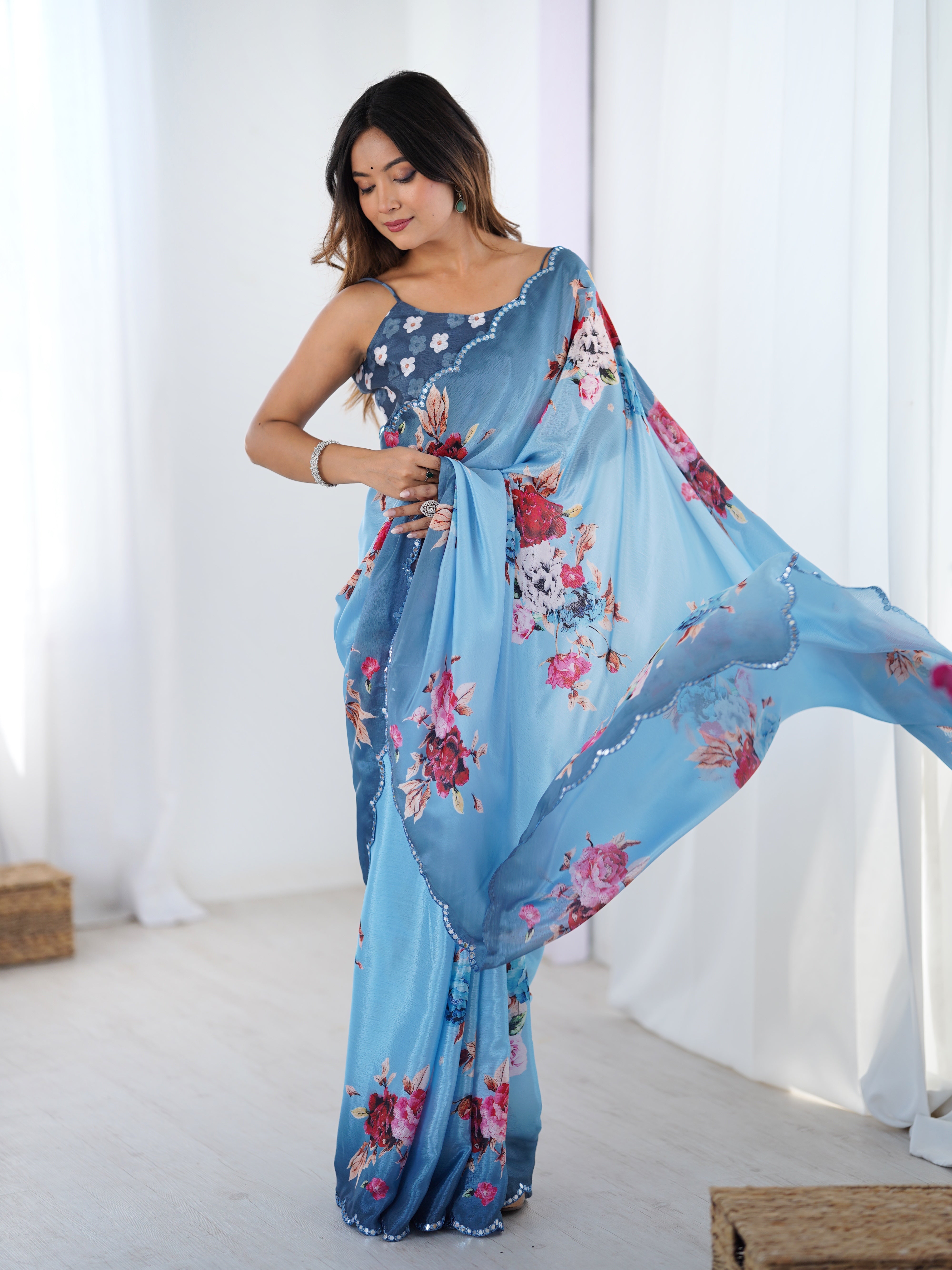 Sky blue Chinnon saree with floral print and Kutchi mirror work lace border.