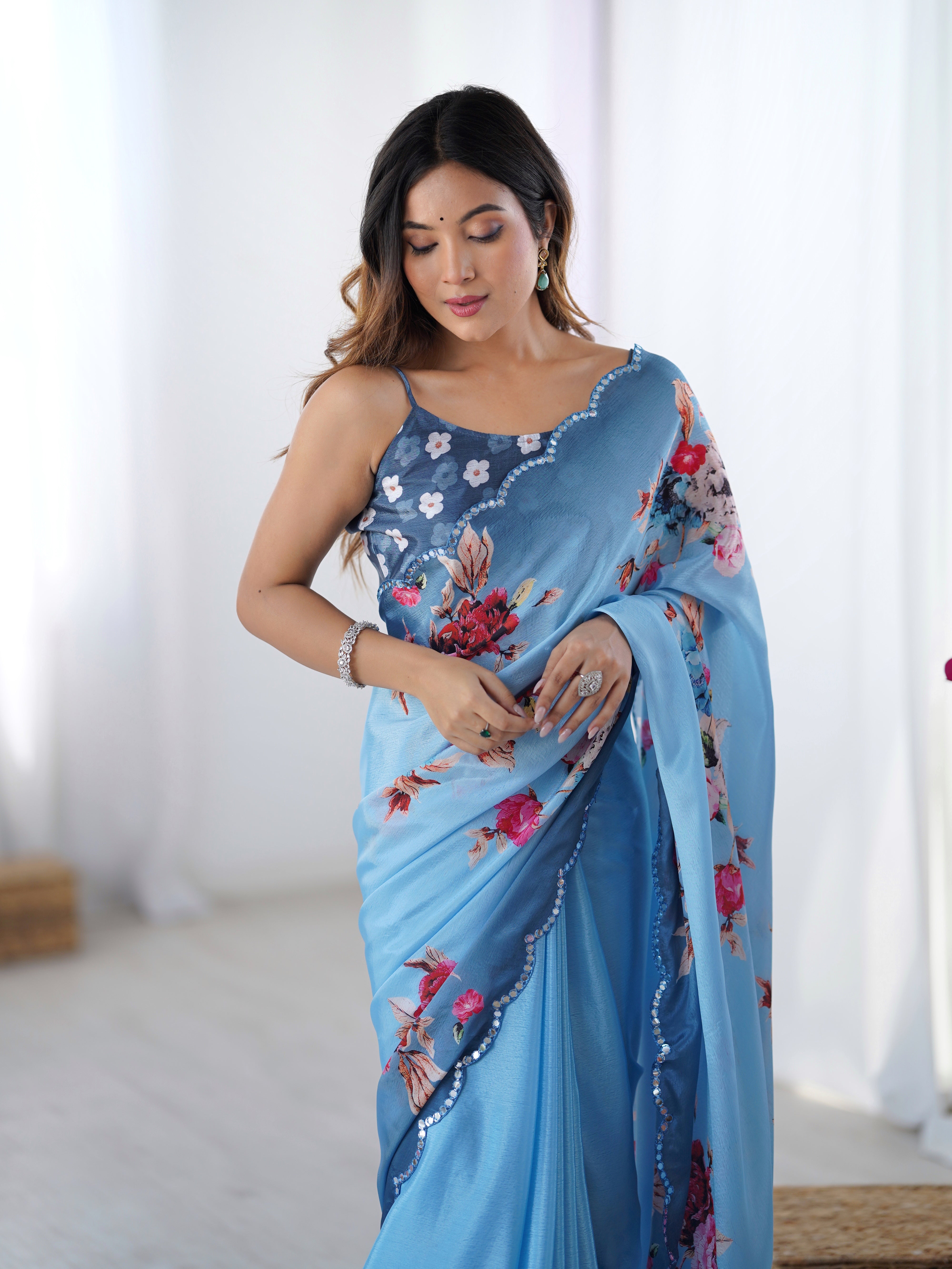 Elegant sky blue Chinnon saree with floral print & Kutchi mirror work lace border.
