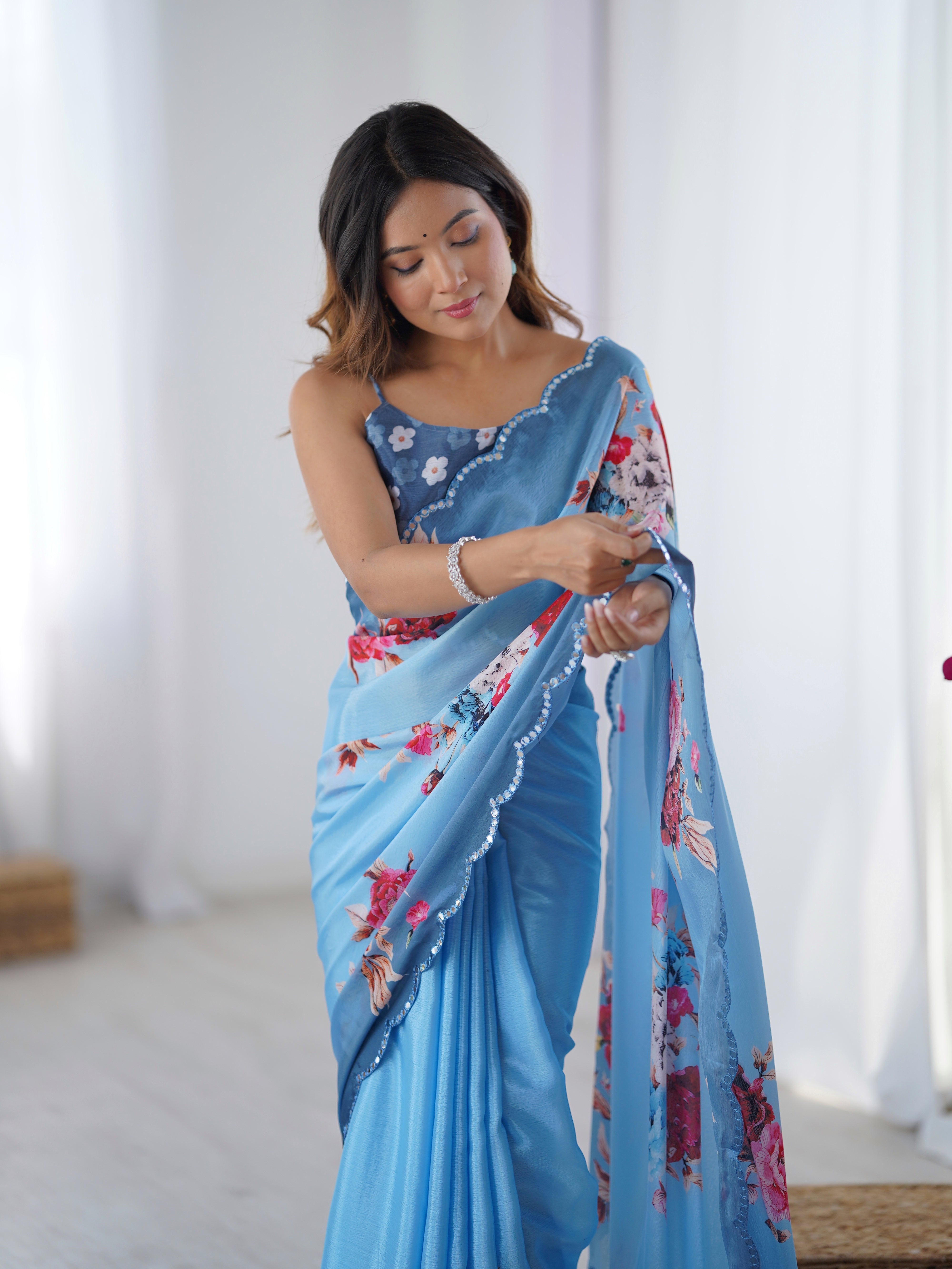 Elegant Sky Blue Chinnon Saree with floral print and Kutchi mirror work lace border.