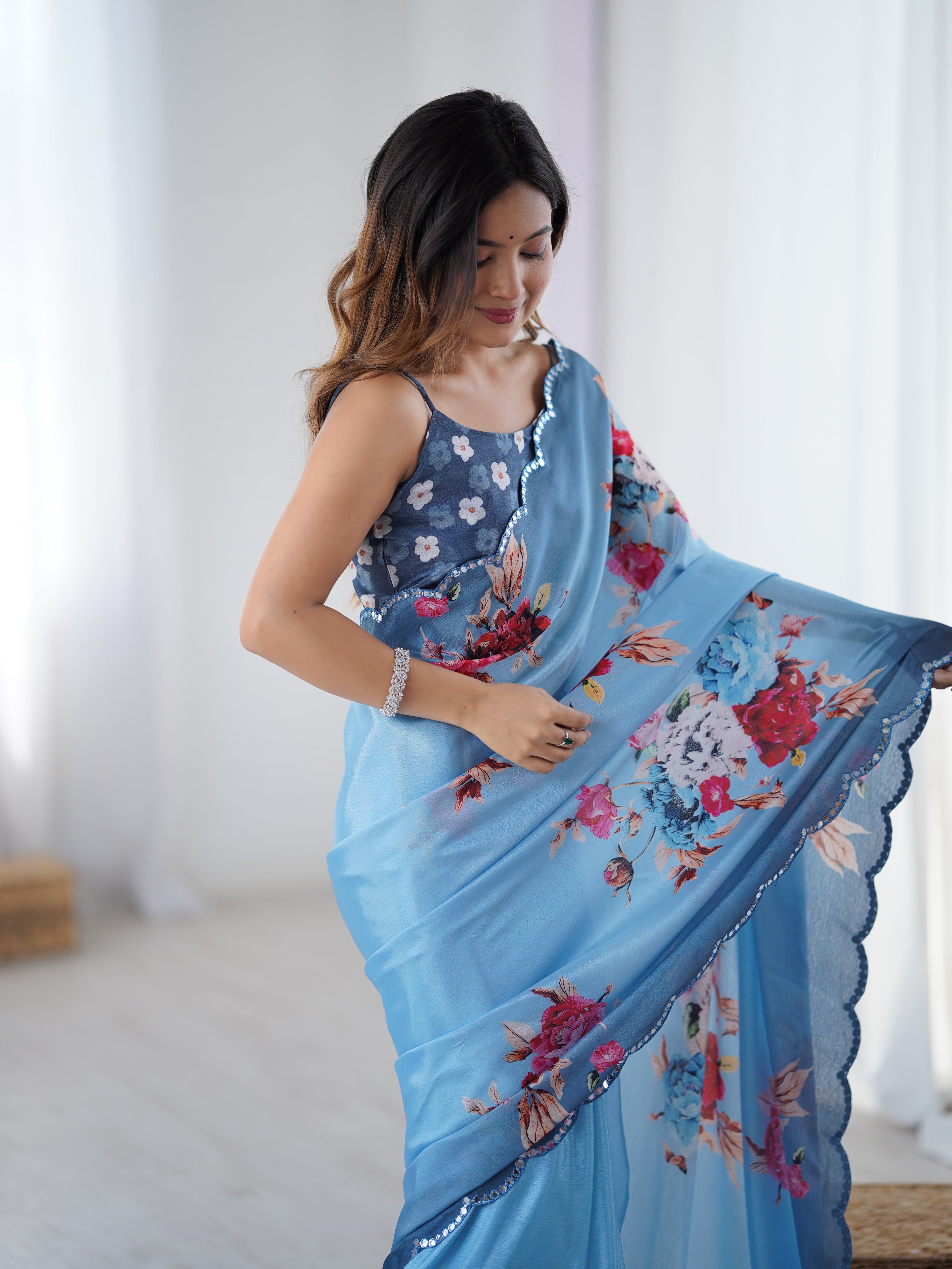 Elegant sky blue chinnon saree with floral print and Kutchi mirror work lace border