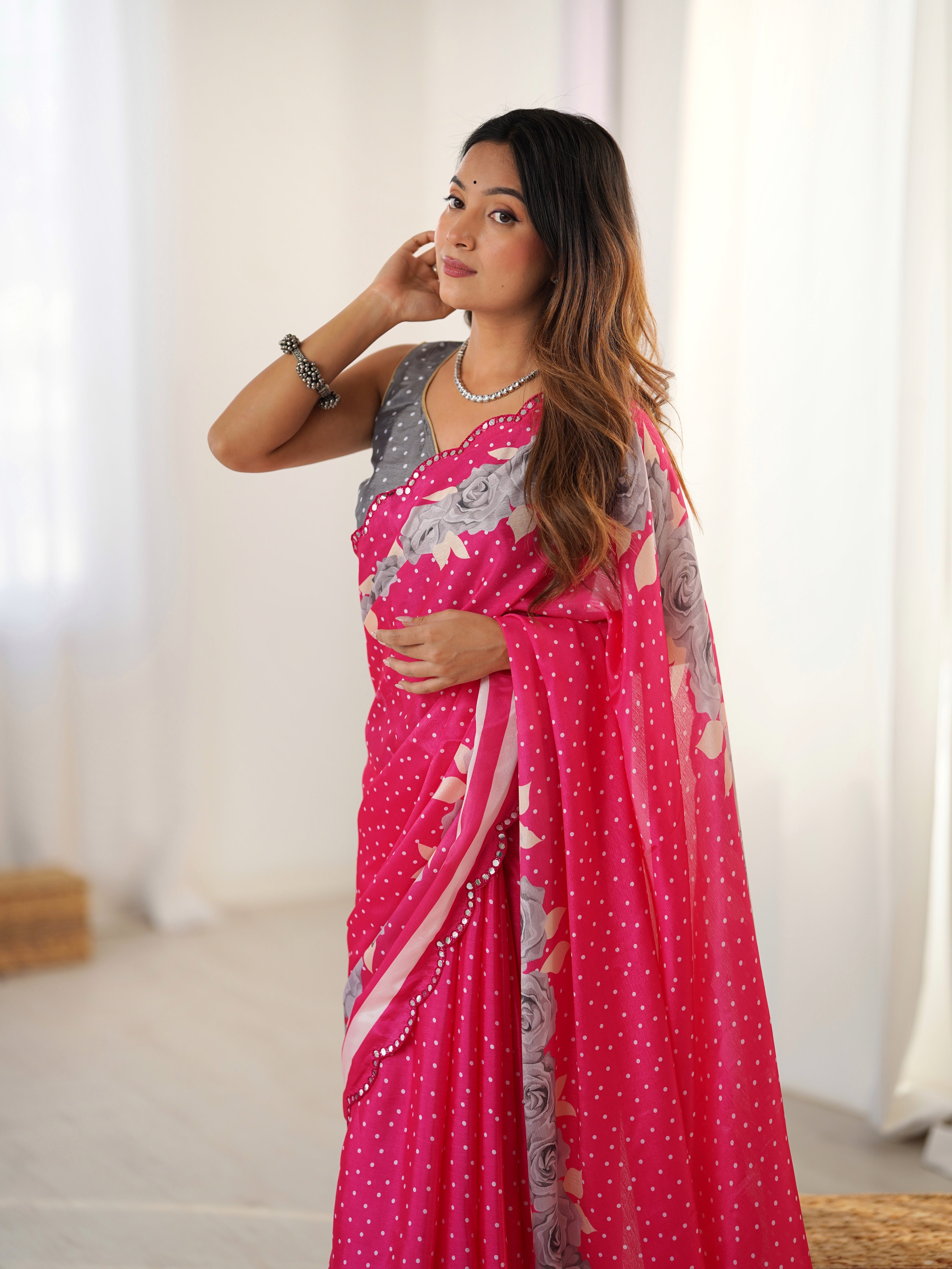 Close-up of elegant pink Chinnon saree showing intricate Kutchi mirror work lace border