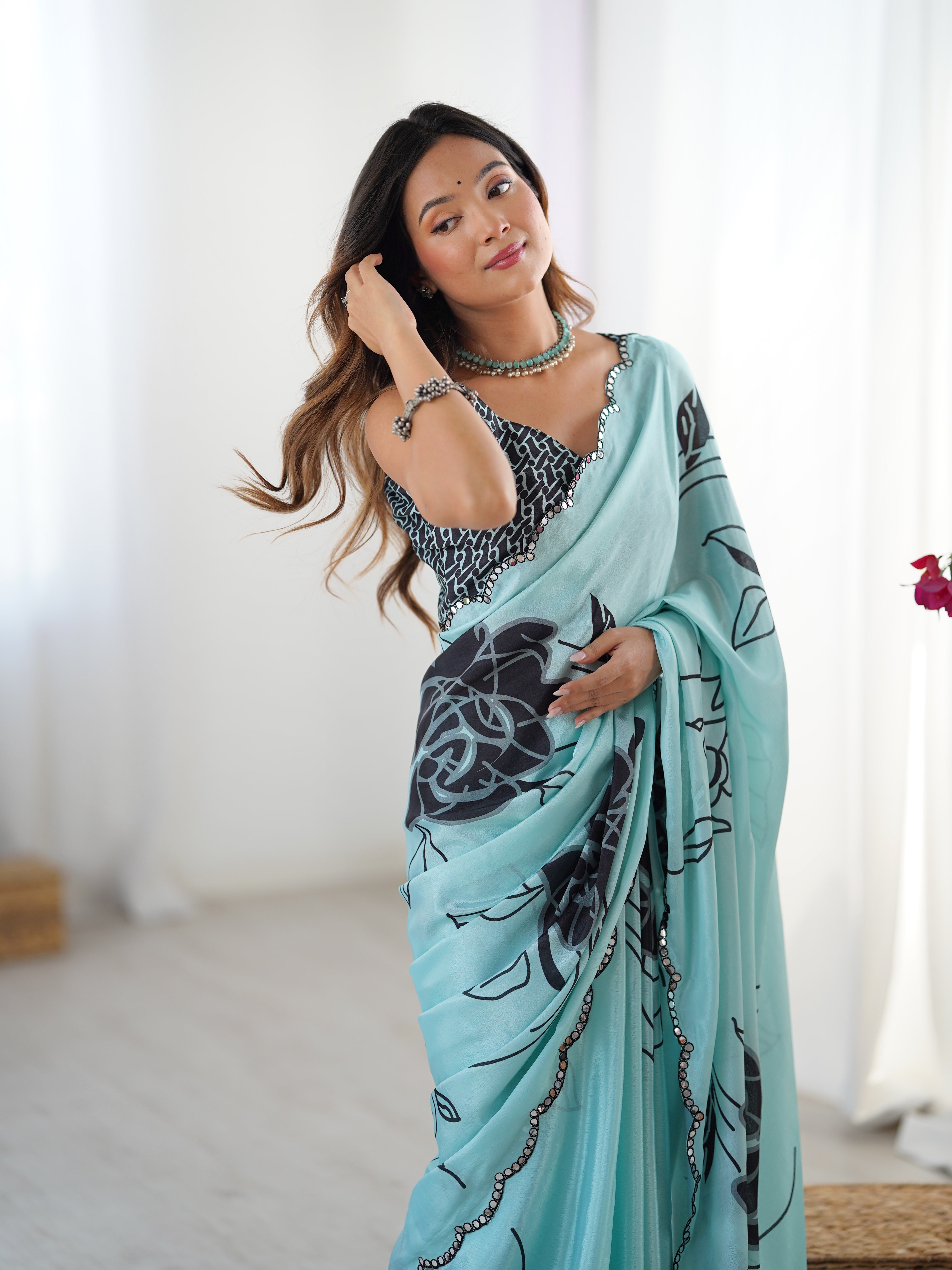 Exquisite aqua Chinnon saree featuring elegant floral print and dazzling Kutchi mirror work border