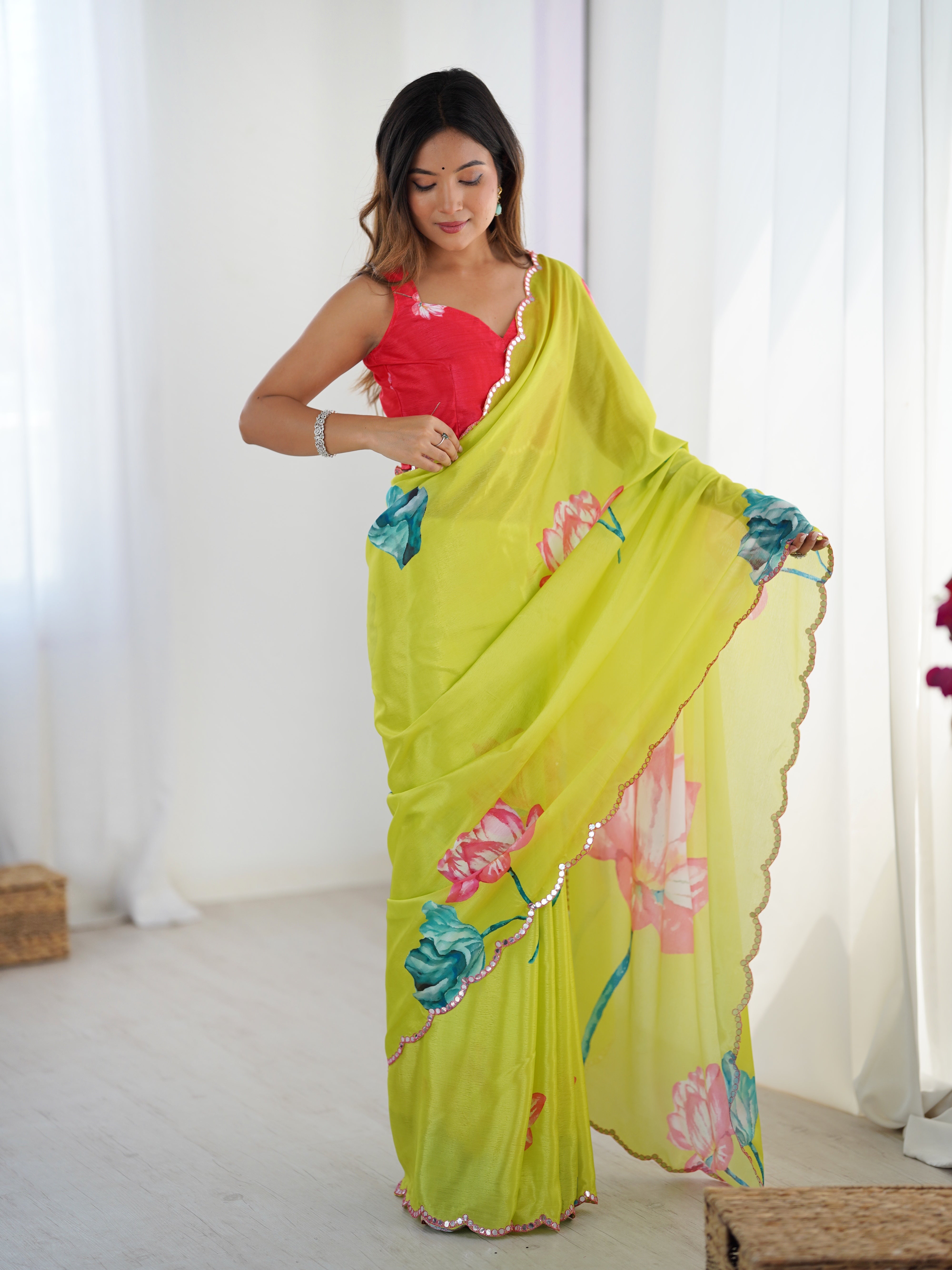 Woman wearing vibrant floral print heavy chinnon saree with Kutchi mirror lace border.