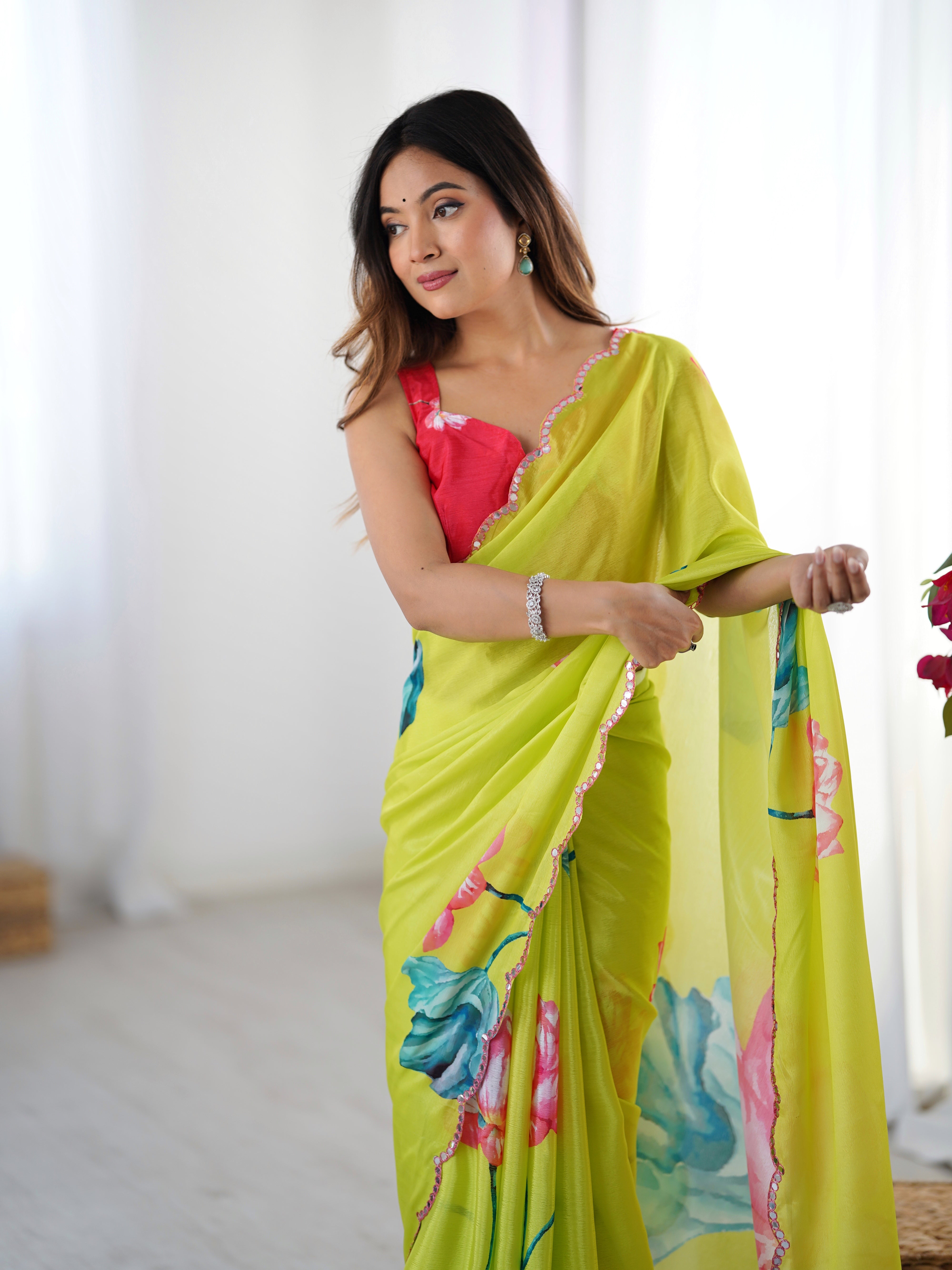 Vibrant floral print heavy Chinnon saree with Kutchi mirror lace border detail.