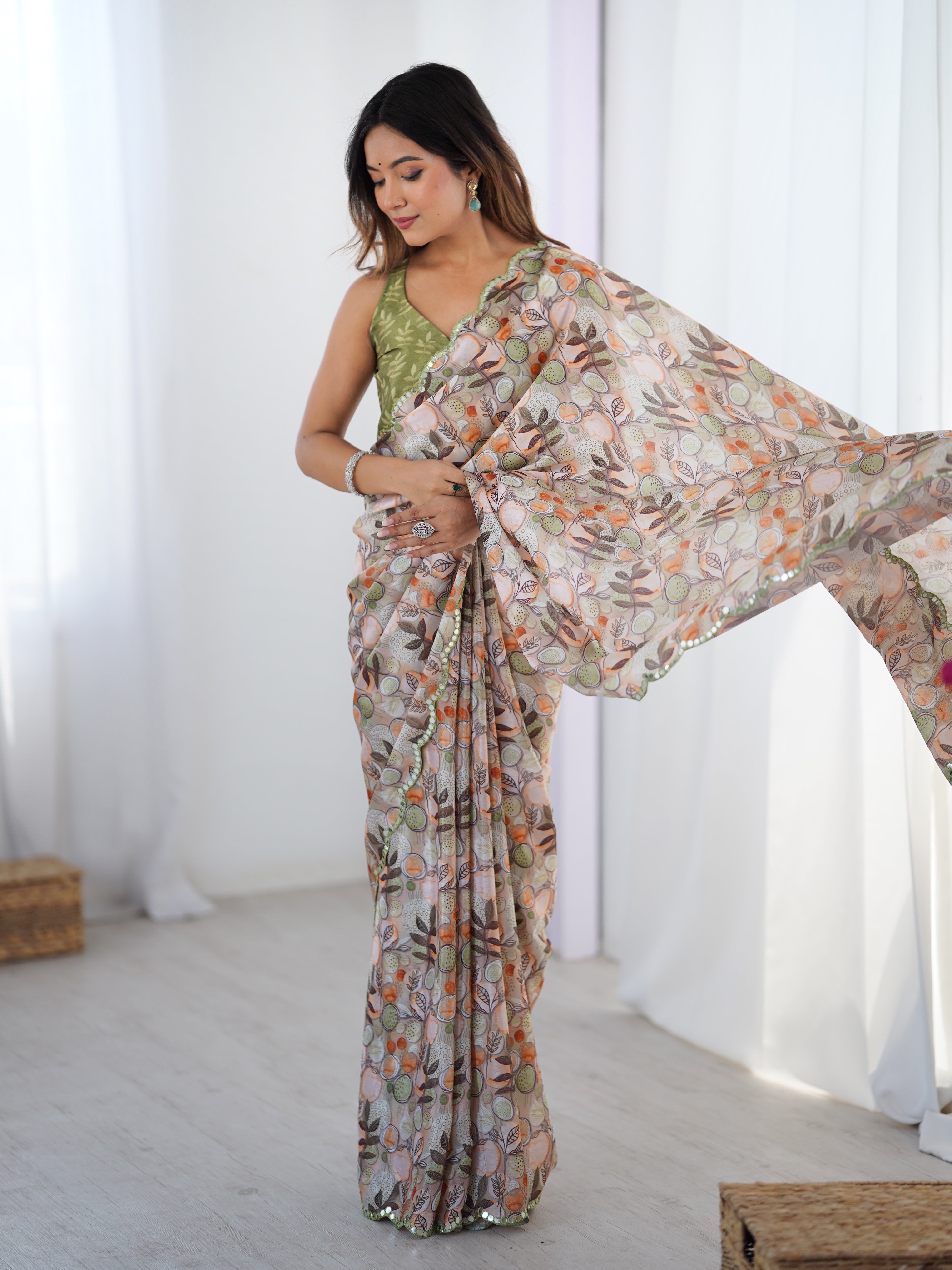 Woman elegantly posing in a printed gold crush saree with sequin border and green blouse, showcasing TRENDBUY fashion.