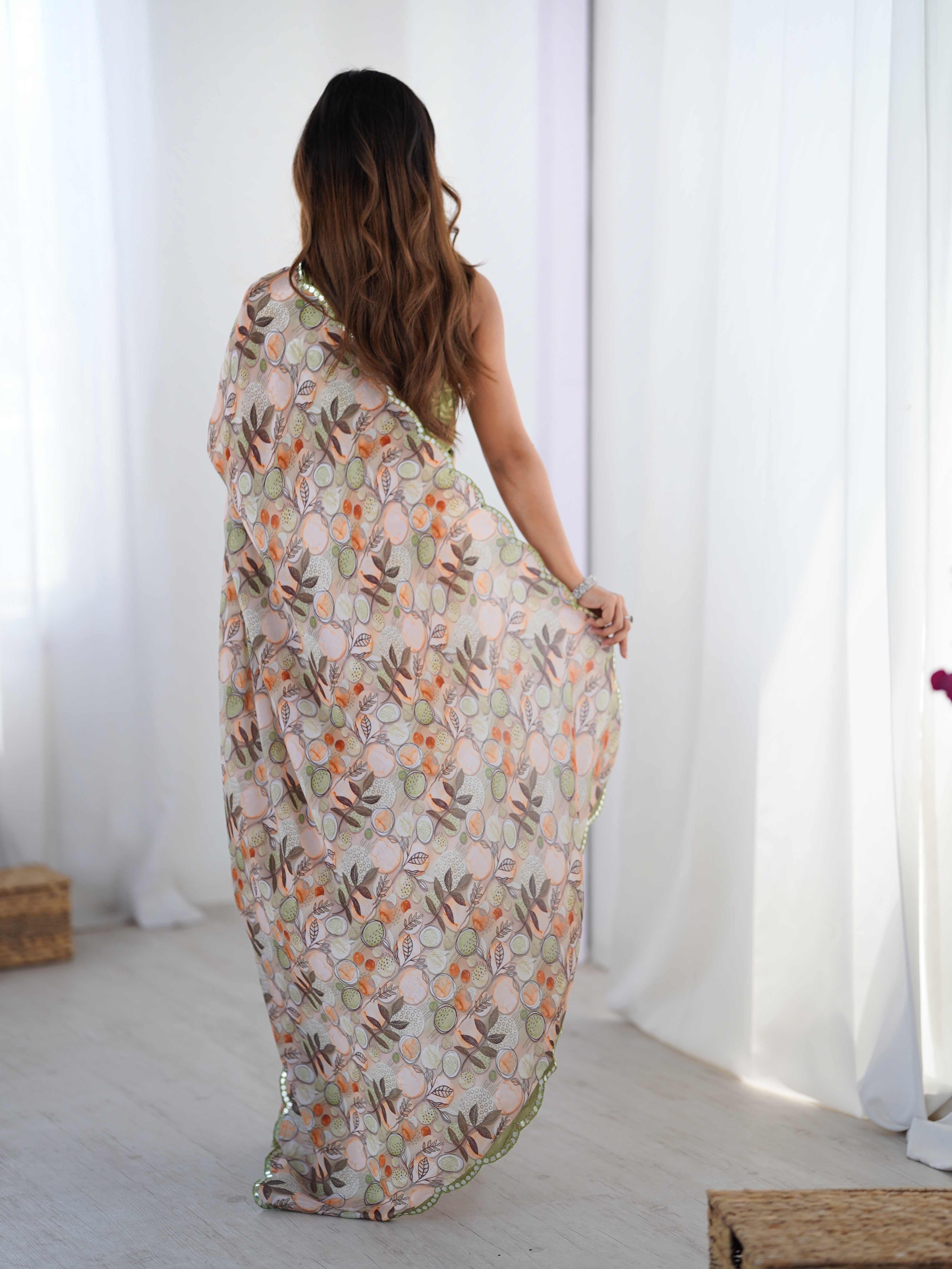 Back view of a woman walking, showcasing the beautiful all-over print and flow of the TRENDBUY gold crush saree.