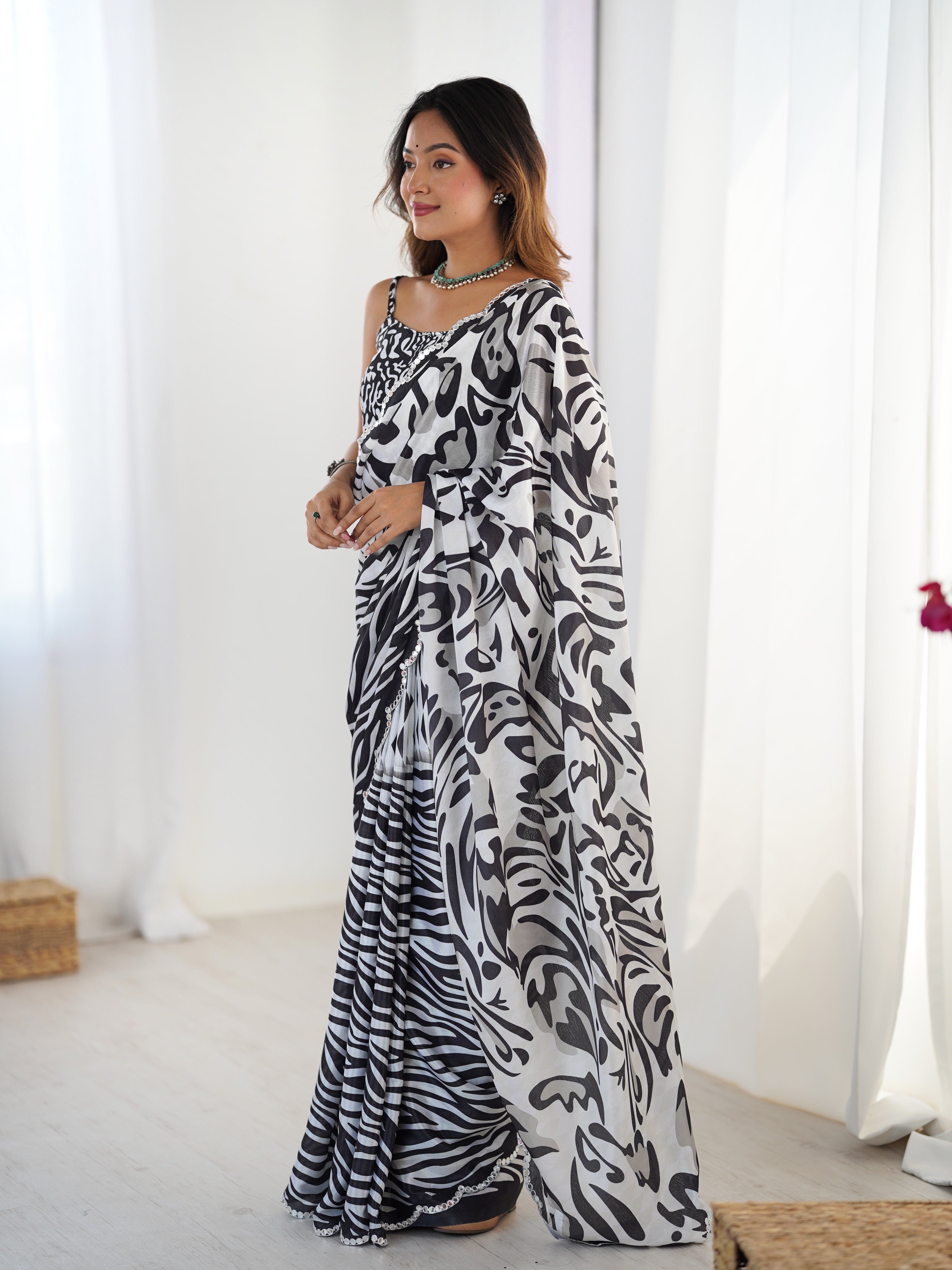 Woman modeling a chic black & white Chinnon saree with a Kutchi mirror lace border