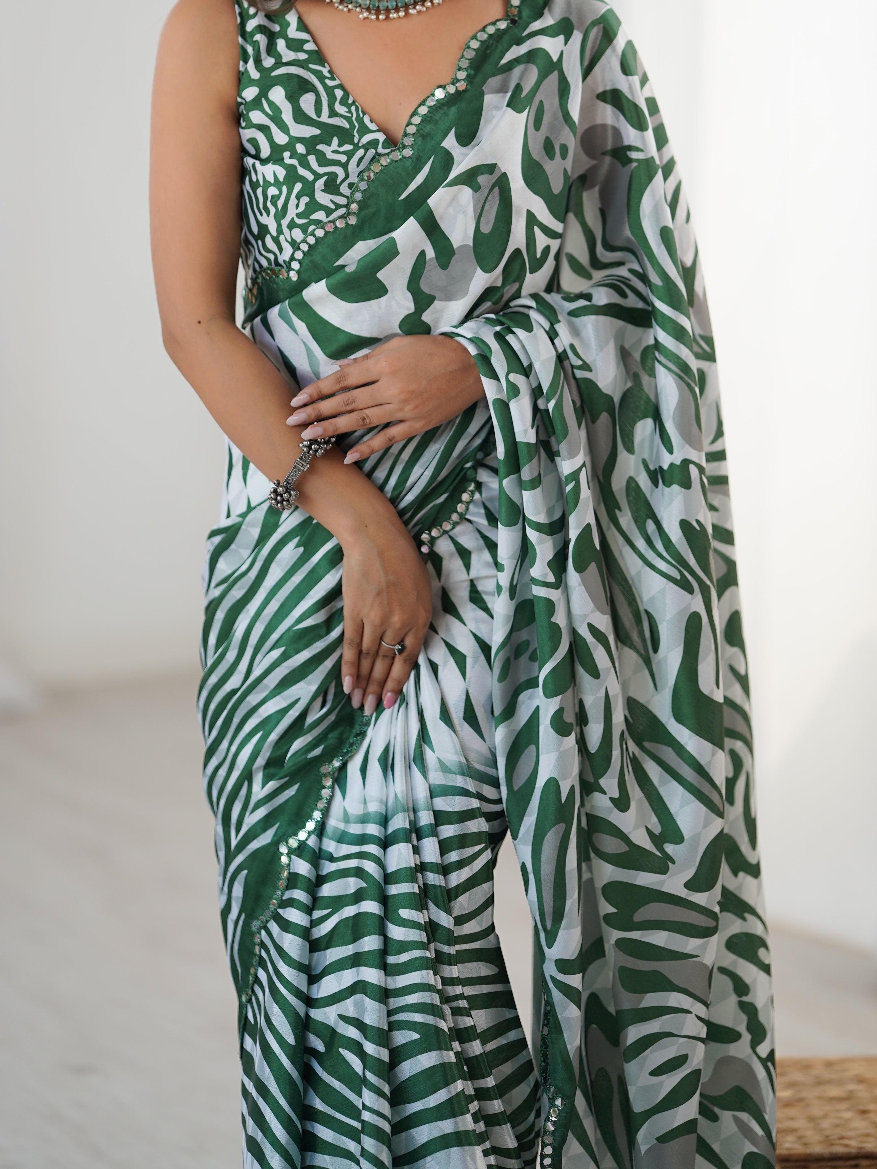 Elegant heavy Chinnon saree featuring an intricate Kutchi mirror work border, displayed with unstitched blouse fabric.