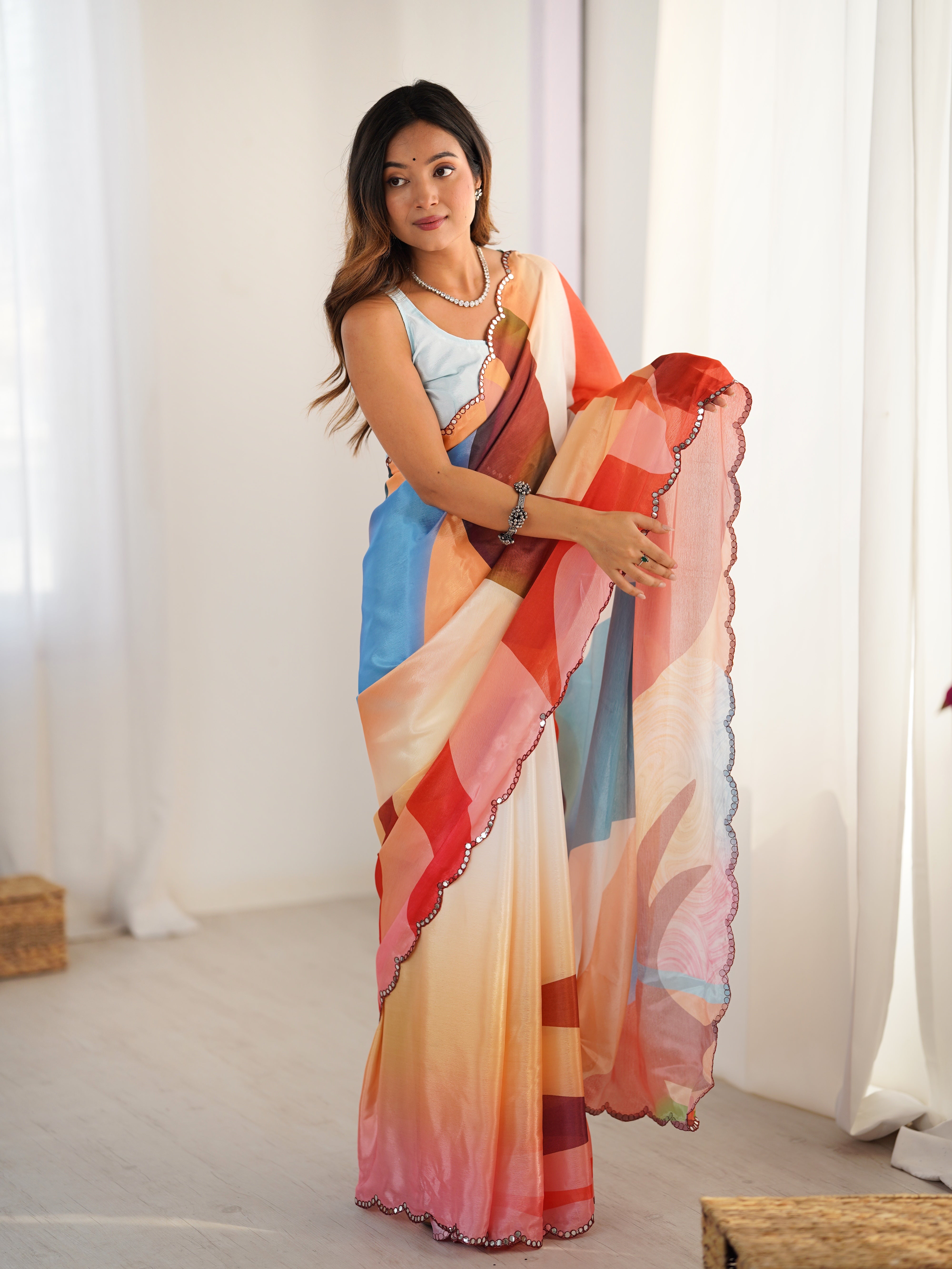 Heavy Chinnon Saree with vibrant print and Kutchi mirror work border, worn by model.