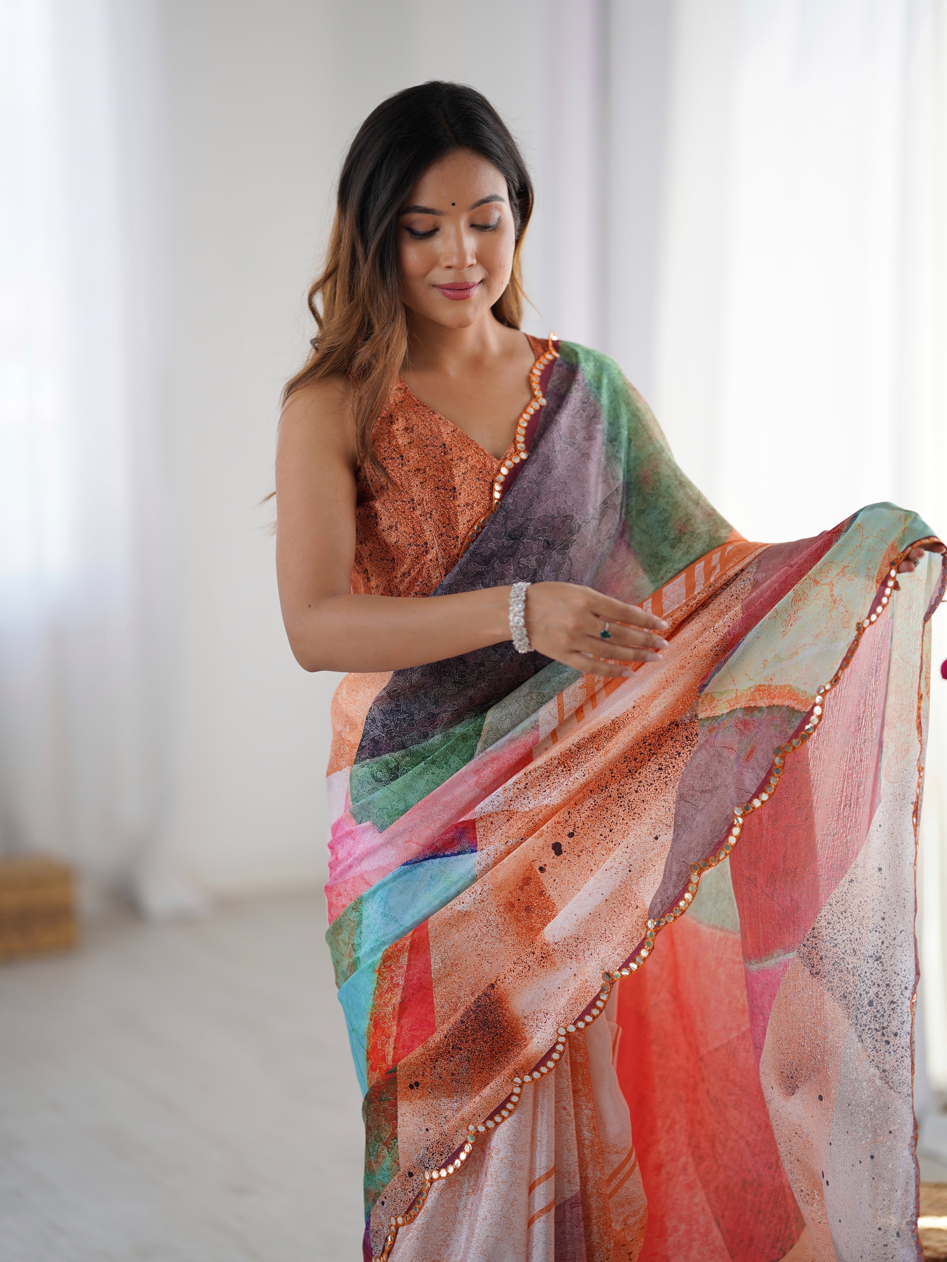 Vibrant abstract print heavy chinnon saree, showcasing Kutchi mirror lace border detail.