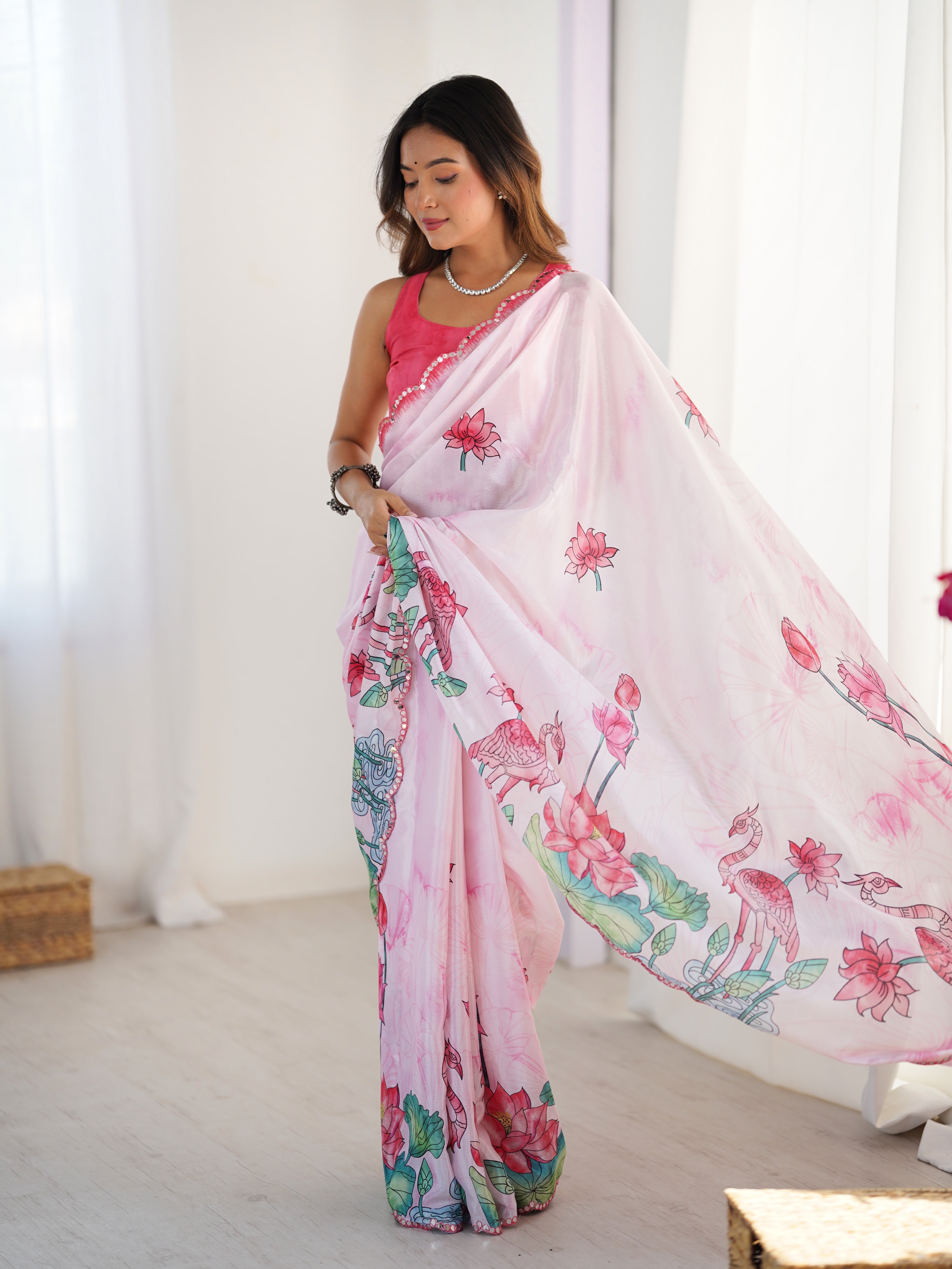 Elegant pink Chinnon saree with a close-up of its intricate Kutchi mirror work lace border.