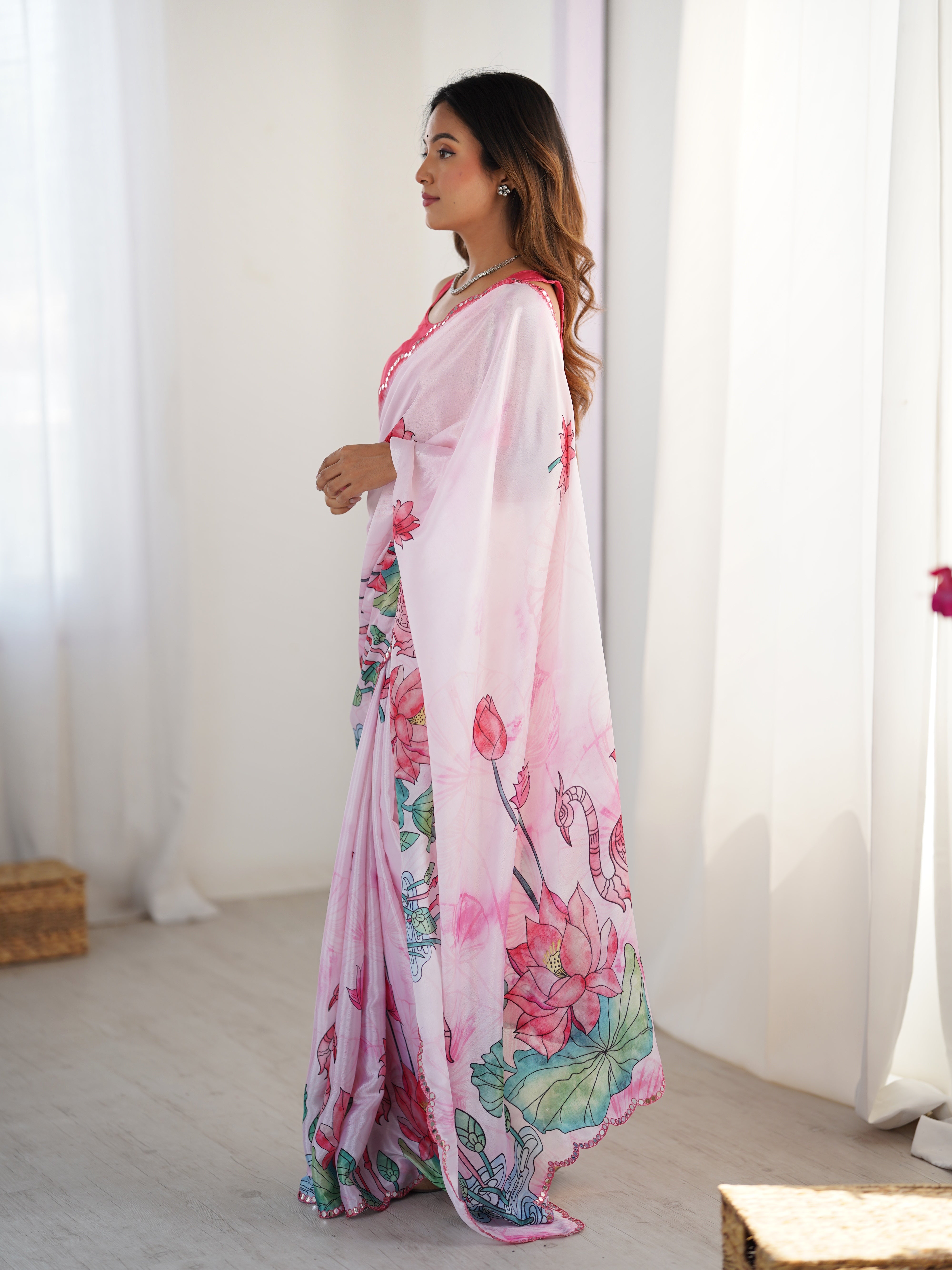 Elegant pink Chinnon saree with intricate Kutchi mirror work and a decorative lace border.