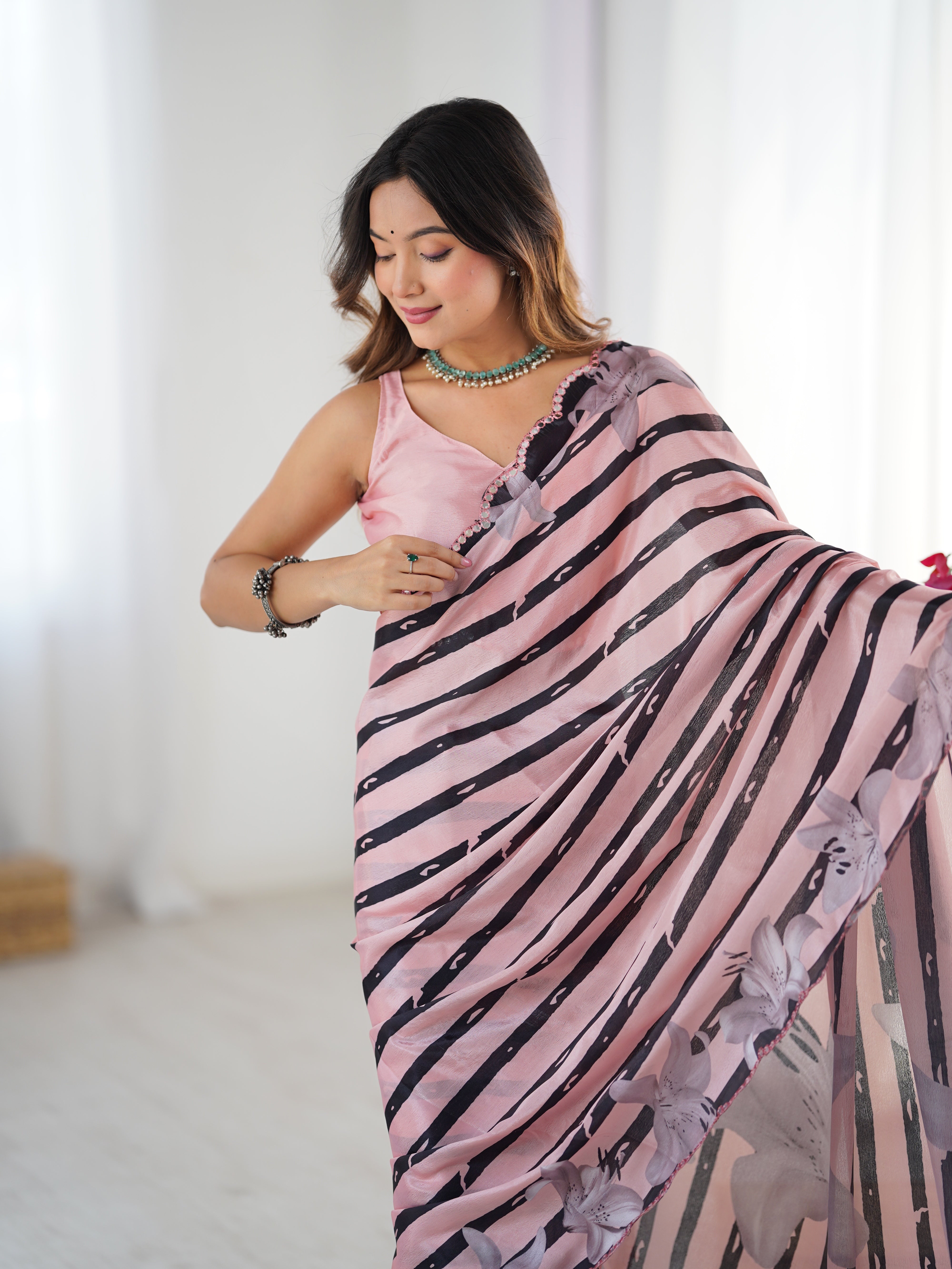 Elegant pink Chinnon saree with floral print & Kutchi mirror lace border. Includes unstitched blouse.