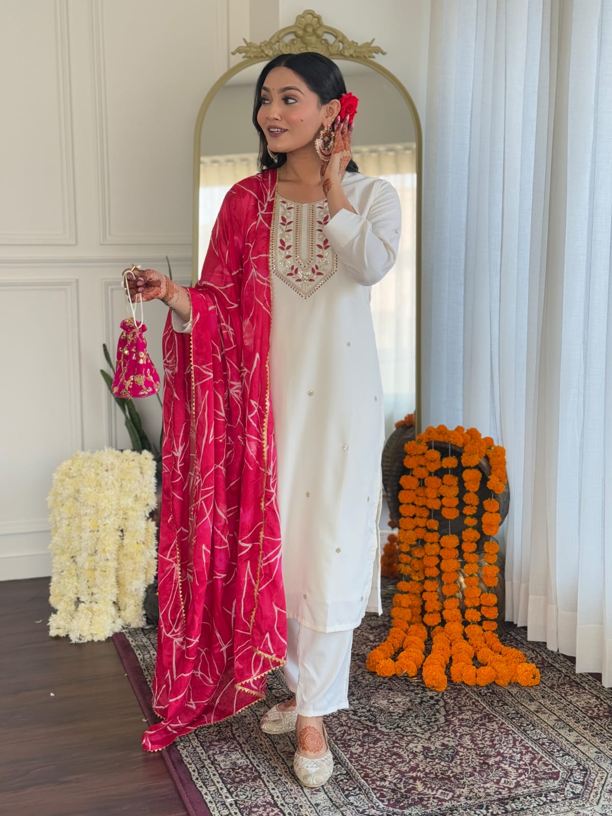 TRENDBUY model in elegant white embroidered rayon kurti set with a vibrant pink chinon foil printed dupatta, holding a matching potli bag.