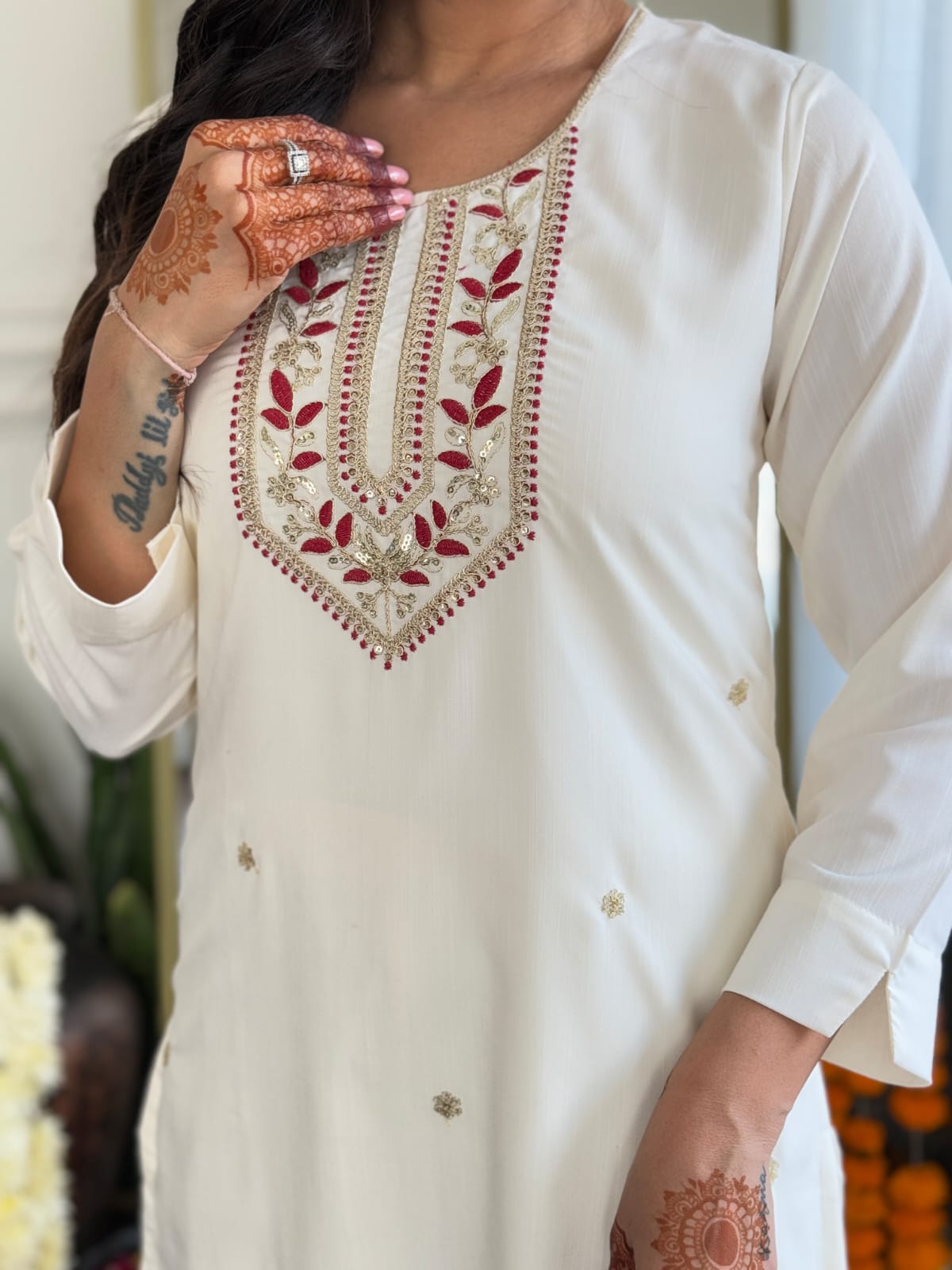 Detailed close-up of the exquisite red and gold embroidery on the neckline of the white rayon slub kurti from TRENDBUY.
