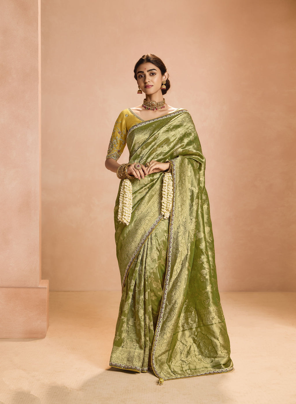 Stunning green zari tissue silk saree with delicate lace border, elegantly draped.