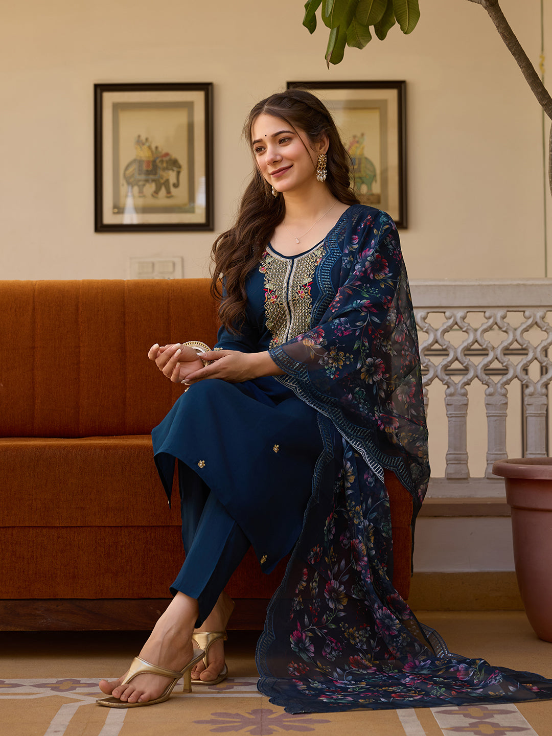 Model sitting gracefully in a TRENDBUY HR-21 deep blue embroidered Viscose Chanderi kurti set with floral Organza dupatta.