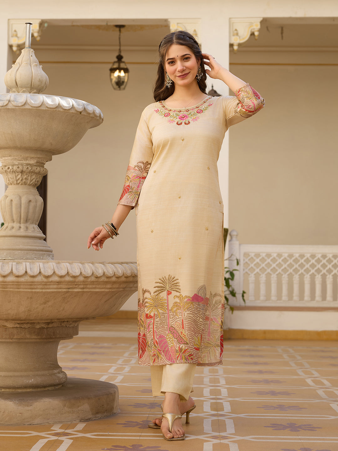 Full-length front shot of the model in the cream Viscose Assam Silk Kurta Set, elegantly posing with a slight smile and a hand near her hair.