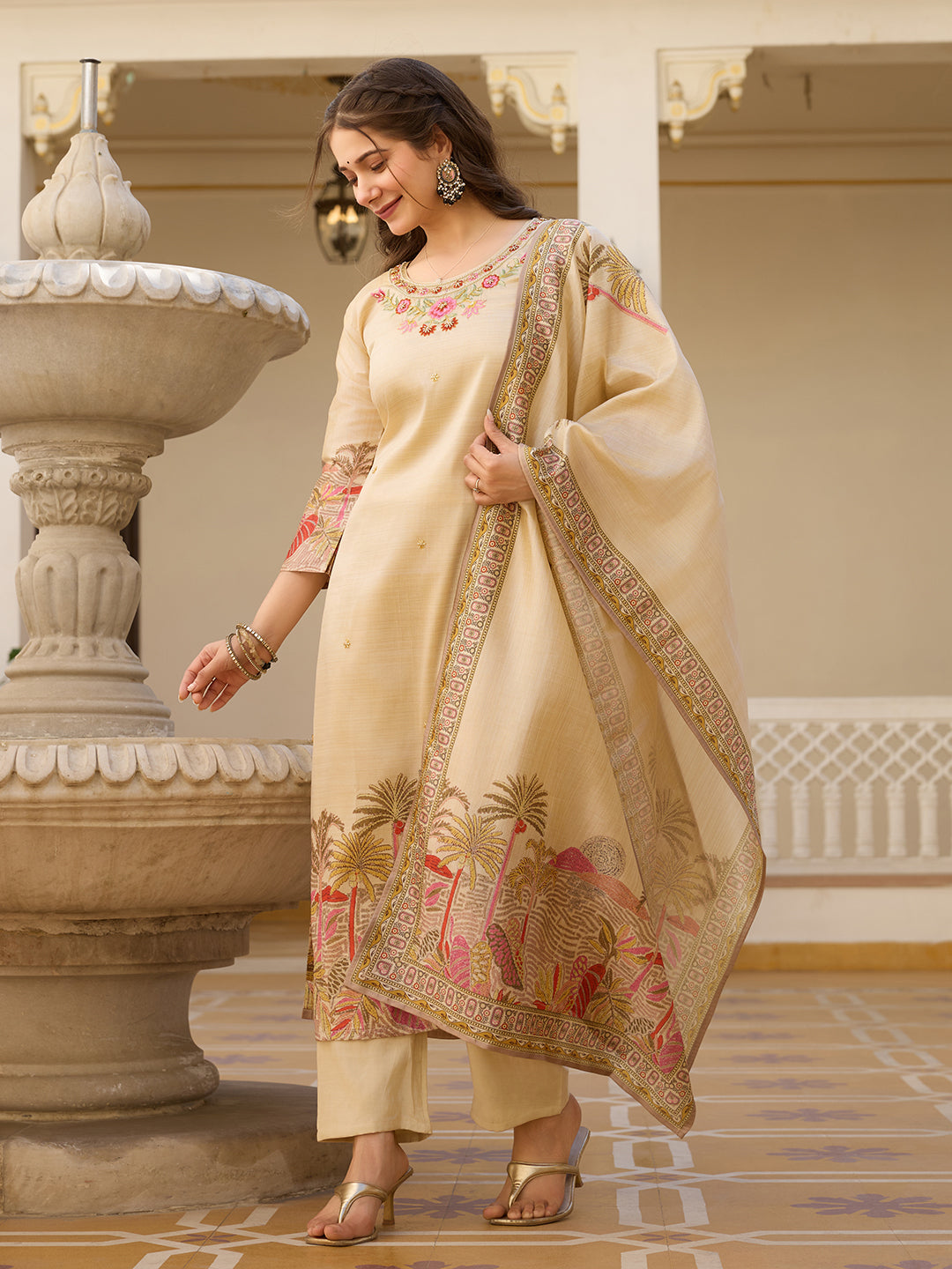 Model confidently posing with the cream Kurta Set and dupatta, revealing the side slit design of the kurta and the intricate prints on the fabric.