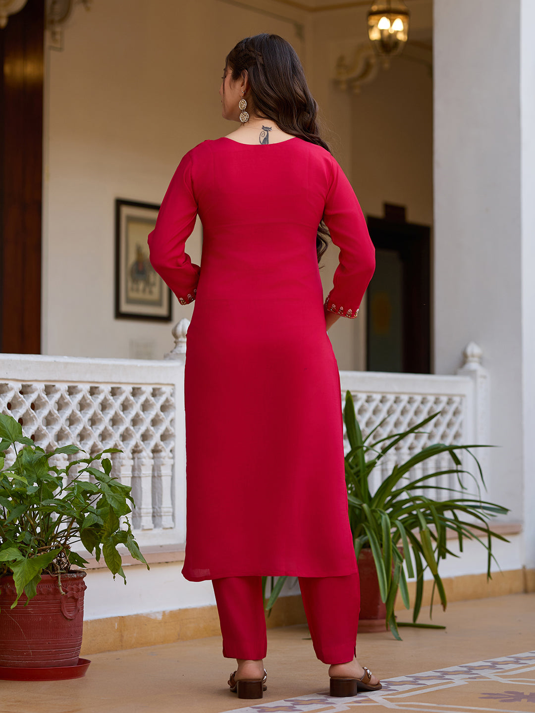 Back view of the woman in the magenta kurti set, showing the elegant plain back and matching pant.