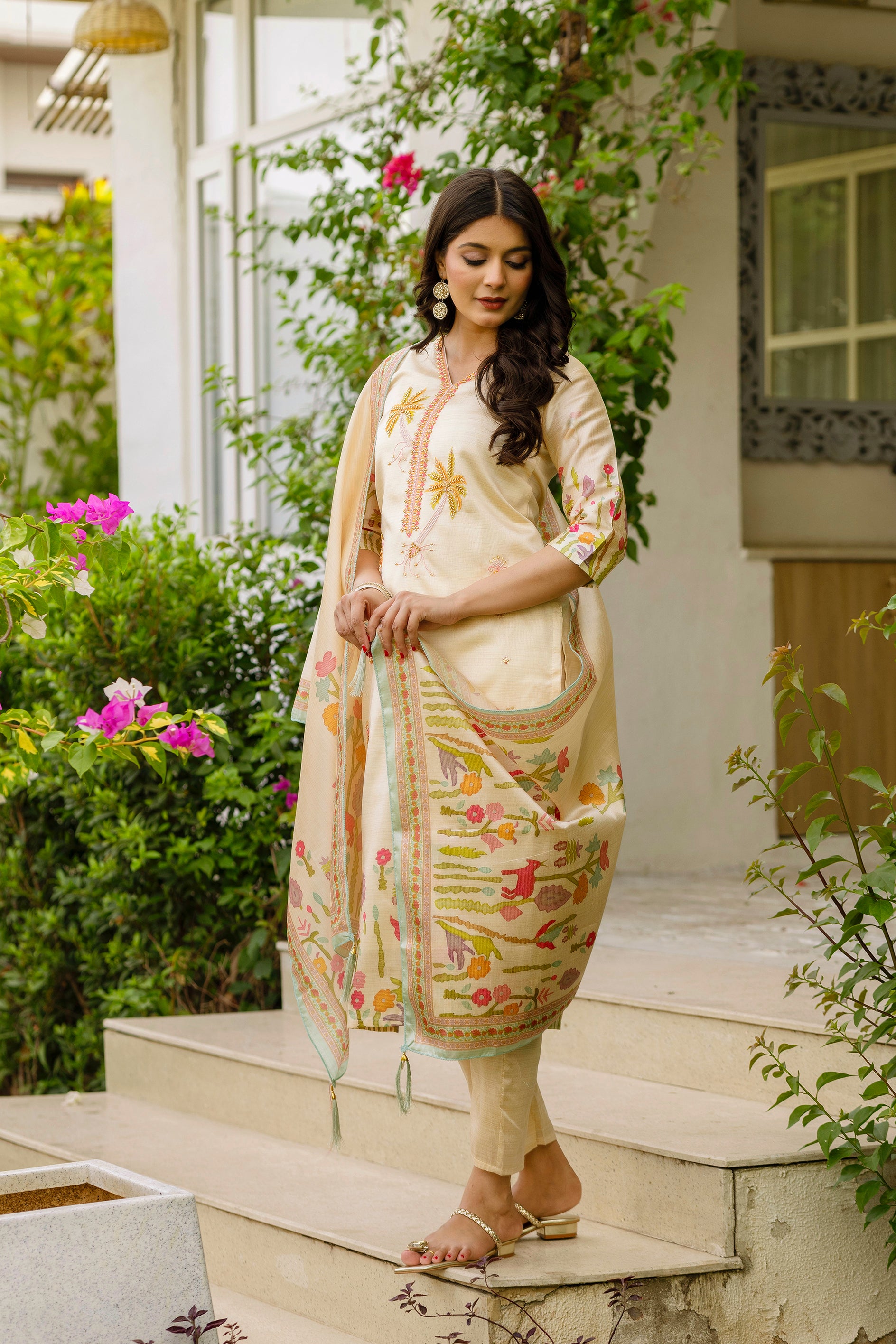 Stylish model looking down at the TRENDBUY cream Kurta Set, emphasizing the detailed beadwork and print on the dupatta.