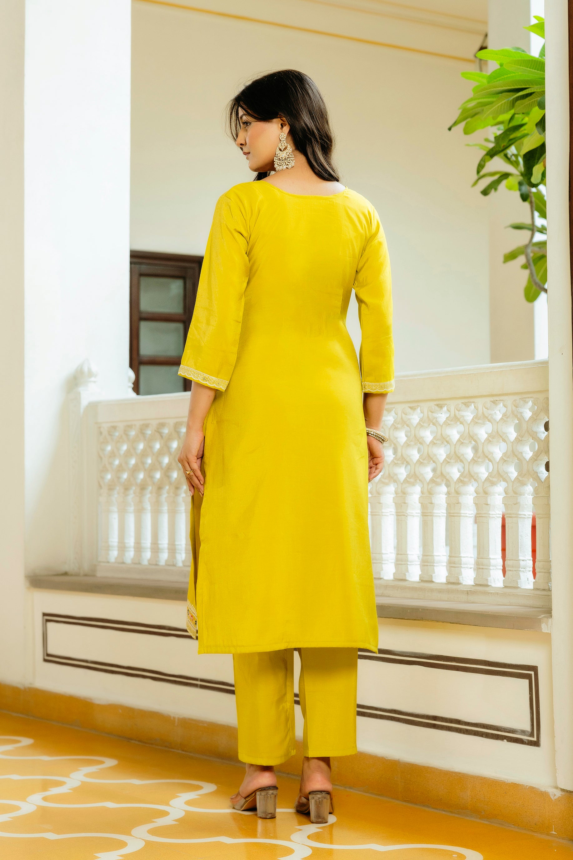 Rear view of the model wearing the bright yellow Viscose Shimar kurta set, highlighting the simple back design of the kurti and the comfortable pant fit.