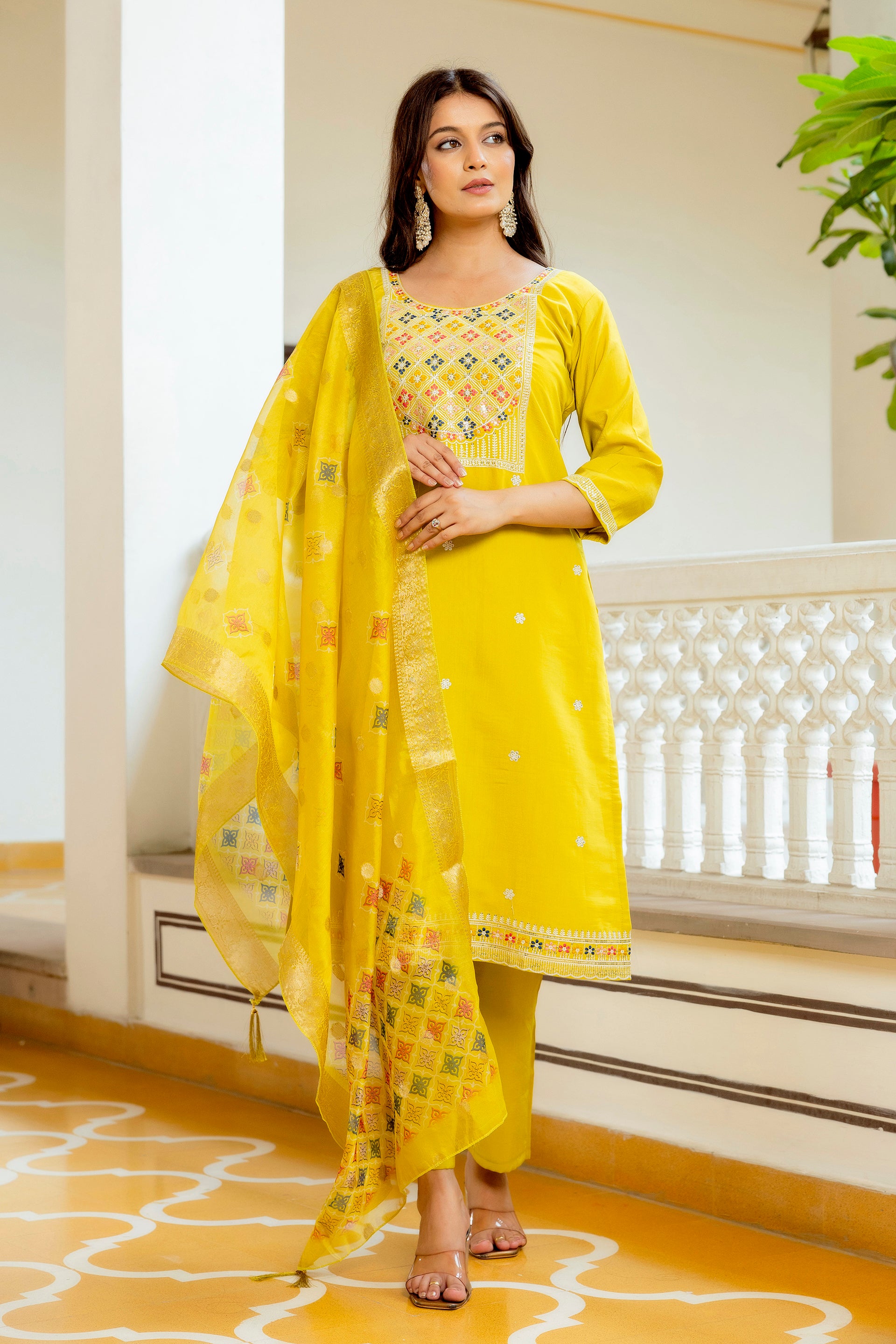 Model in the yellow Viscose Shimar kurta set, hands clasped, highlighting the front embroidery work on the yoke and the overall harmonious ethnic ensemble.