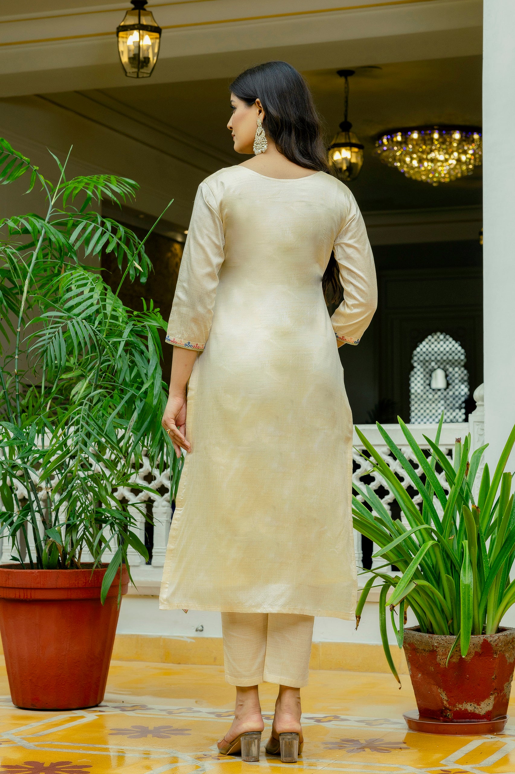 Back view of the model, illustrating the simple yet elegant cut of the beige Viscose Assam Silk kurta and matching pants.