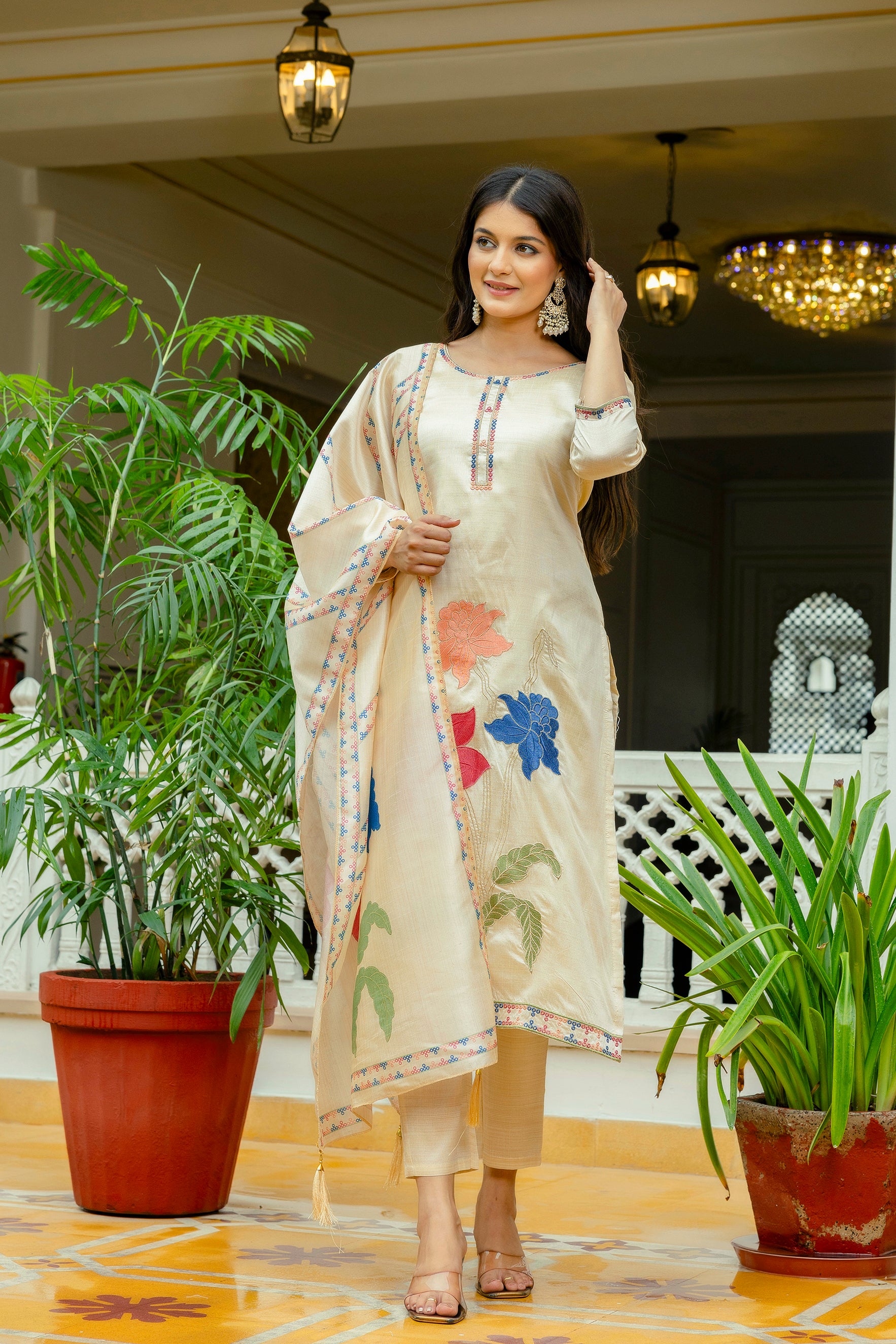 Model posing with a side glance, showcasing the complete TRENDBUY beige kurta, pant, and dupatta set, emphasizing its flattering drape and design.