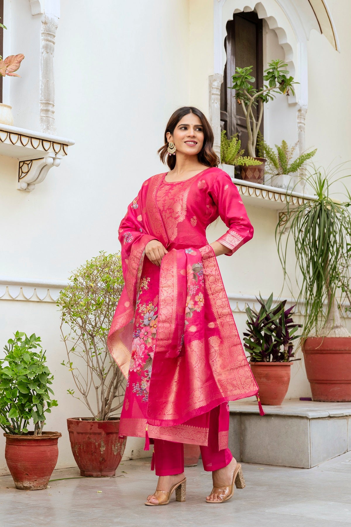 Elegant model looking sideways in the vibrant pink Chanderi cotton kurti set.