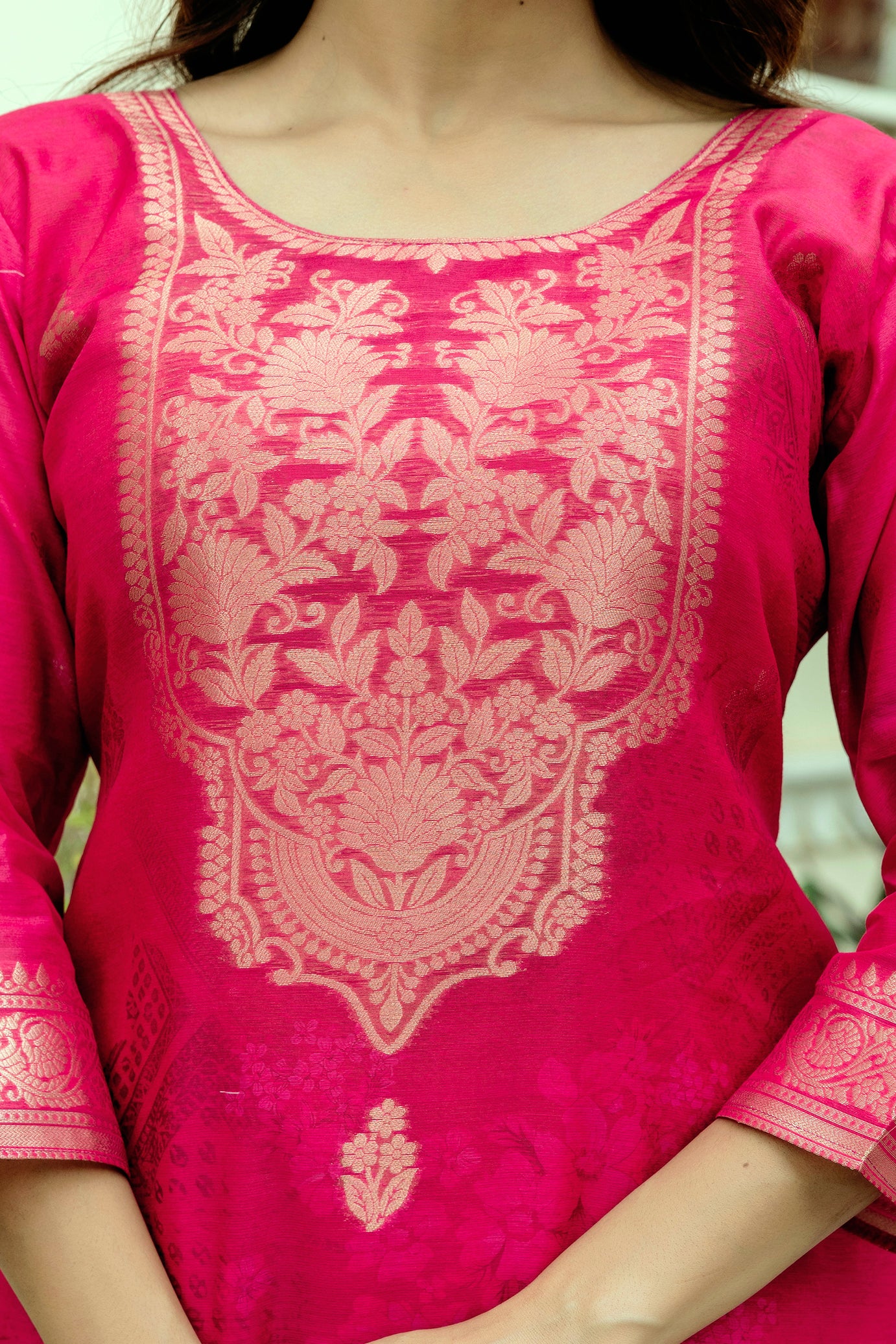 Detailed shot of the golden woven design on the vibrant pink Chanderi kurti.