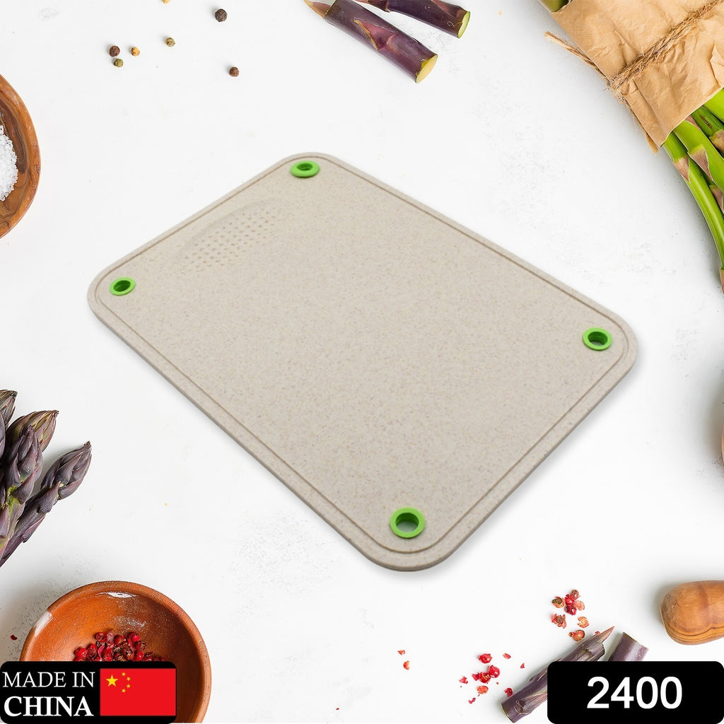 Green plastic double-sided multi-purpose kitchen chopping board for cutting vegetables and fruit.