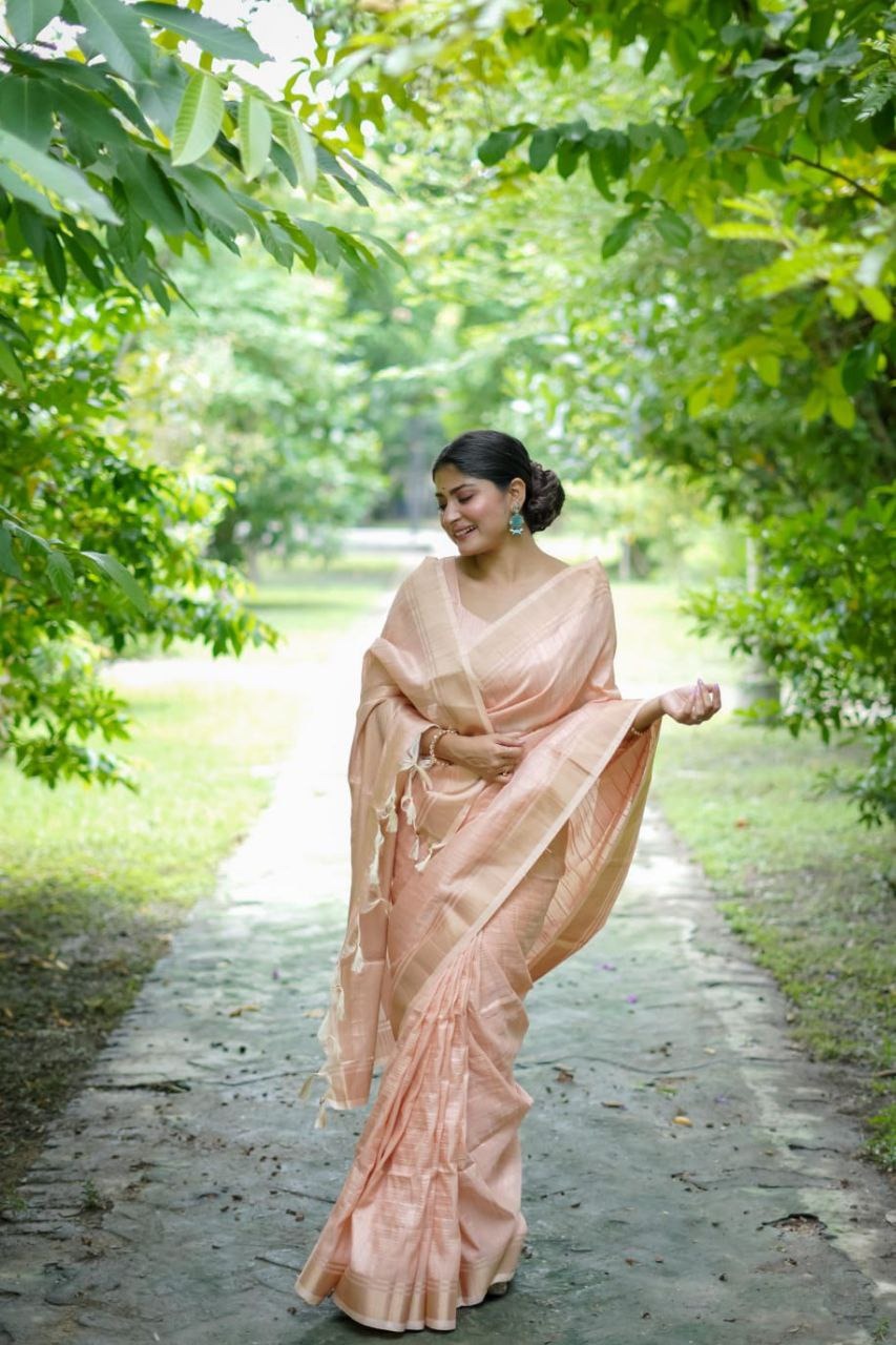 Close-up of the intricate gold zari lining pattern on soft raw silk fabric.