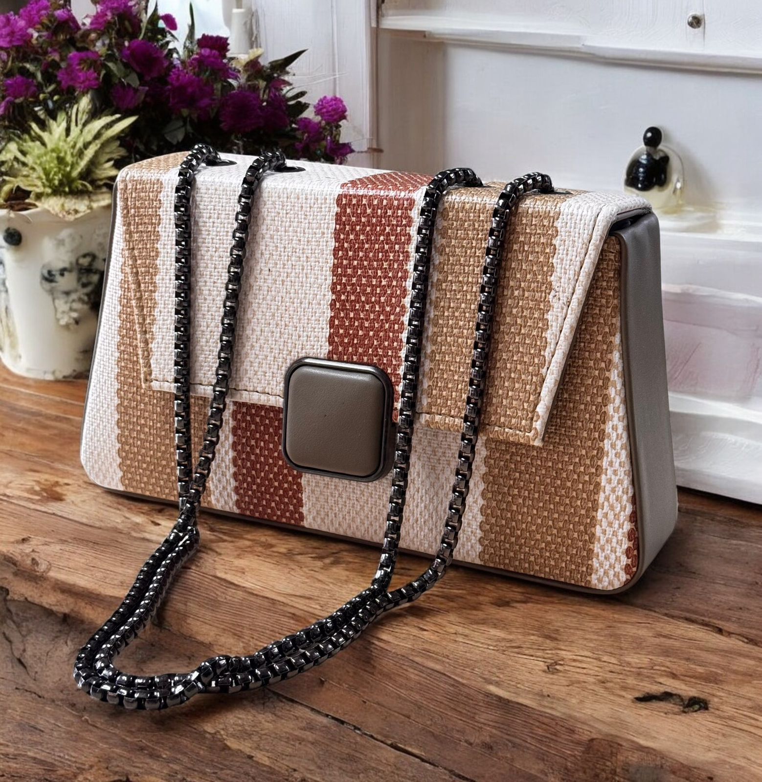 Patchwork handbag with a chain strap on a wooden surface