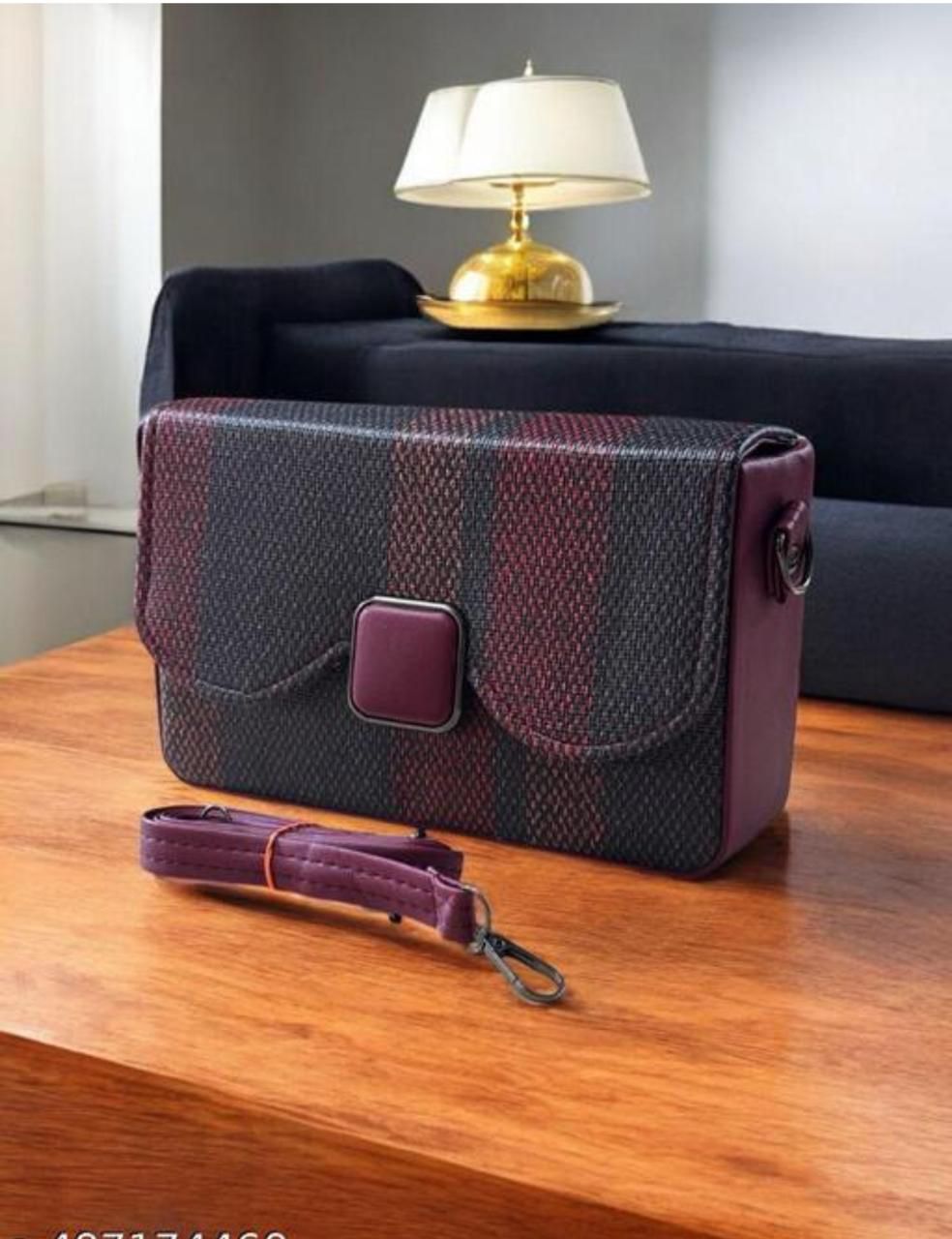 Plaid patterned bag with a strap on a wooden surface, with a blurred background