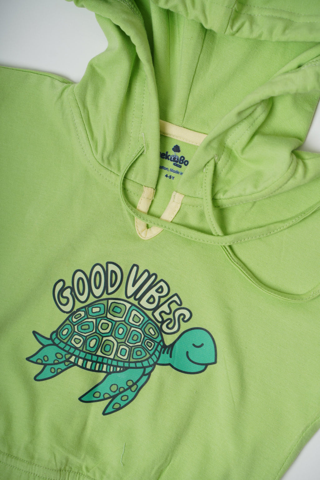 Side view of toddler girl wearing the green sleeveless knit summer hoodie