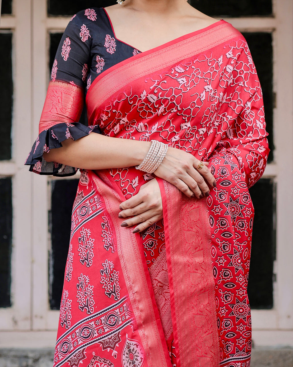 Close-up of woman's mid-section showing details of Ajrakh print red Banarasi silk saree and matching blouse.