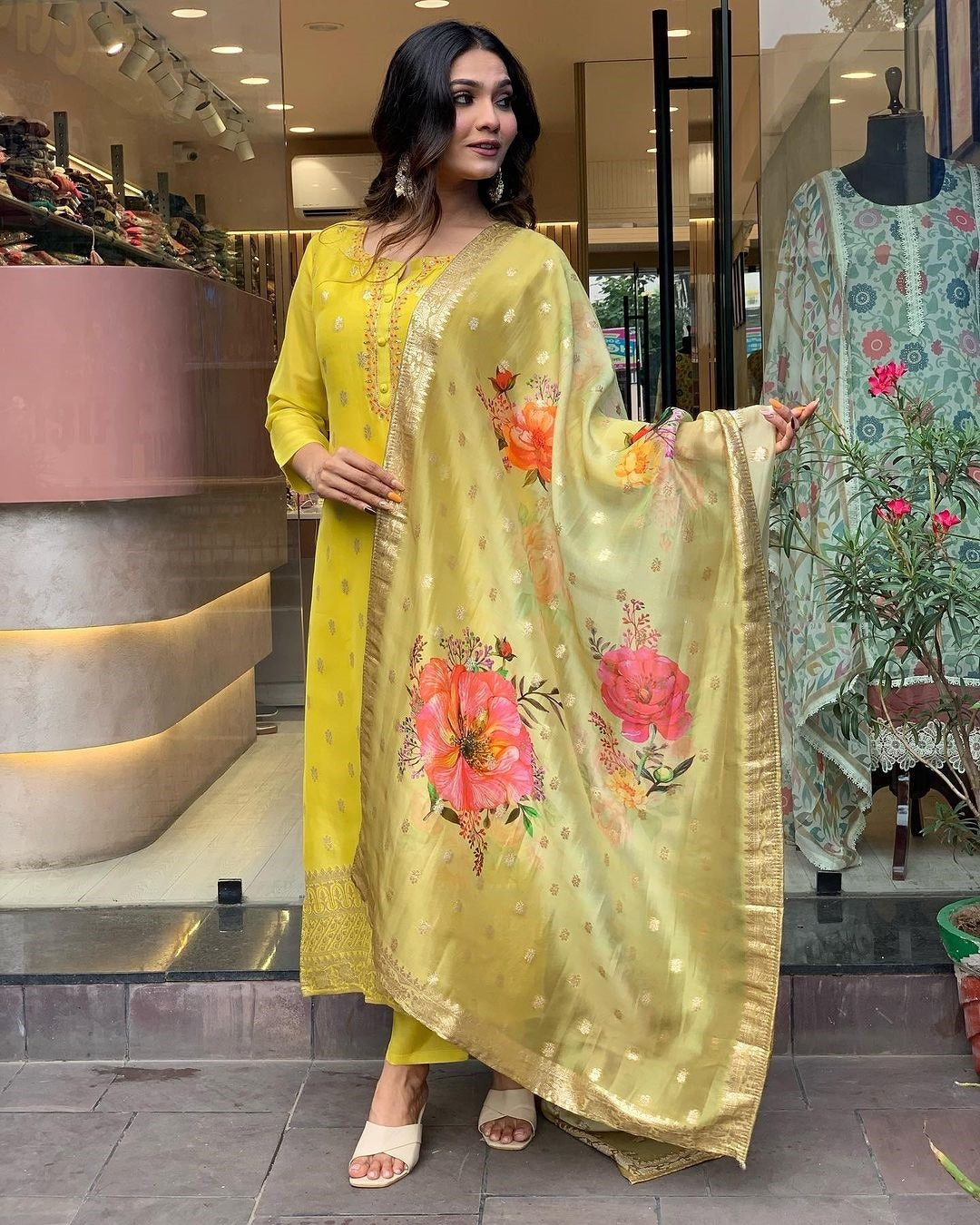 Confidently posing woman modeling yellow viscose organza kurti set with digitally printed jacquard dupatta.