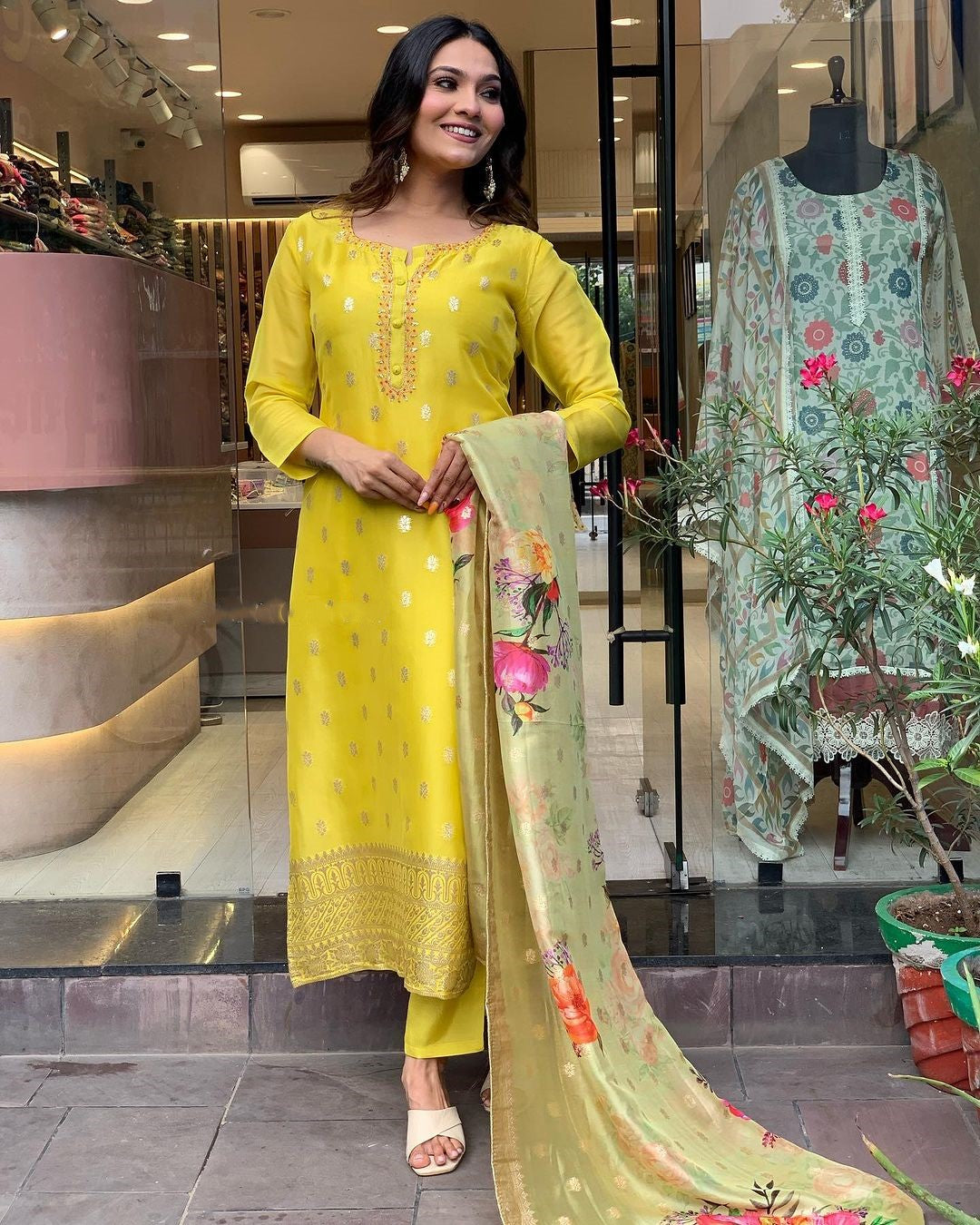 Elegant woman in a yellow embroidered kurta, displaying the matching dupatta with a gentle smile.